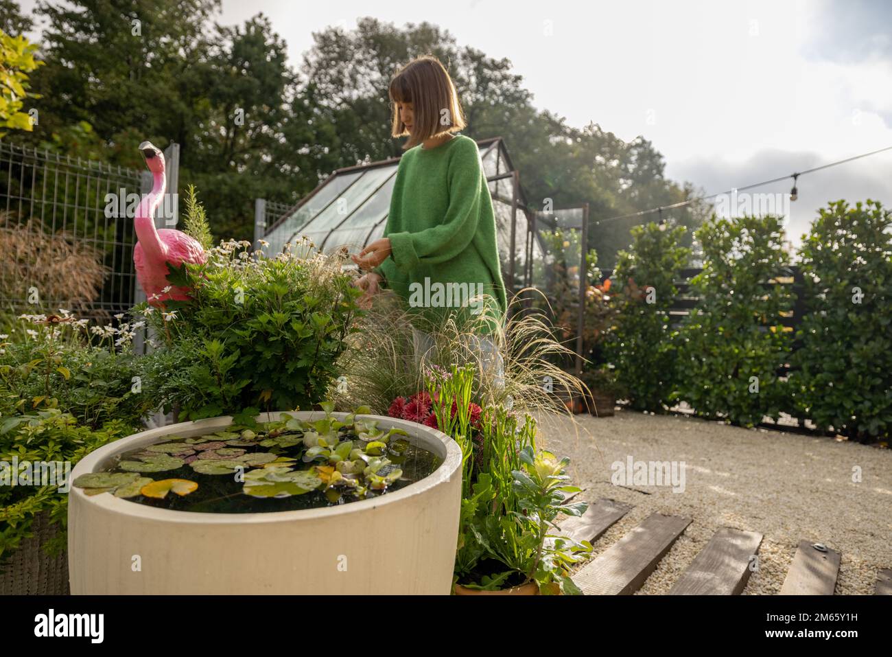 Bel giardino verde con una donna giardinaggio Foto Stock