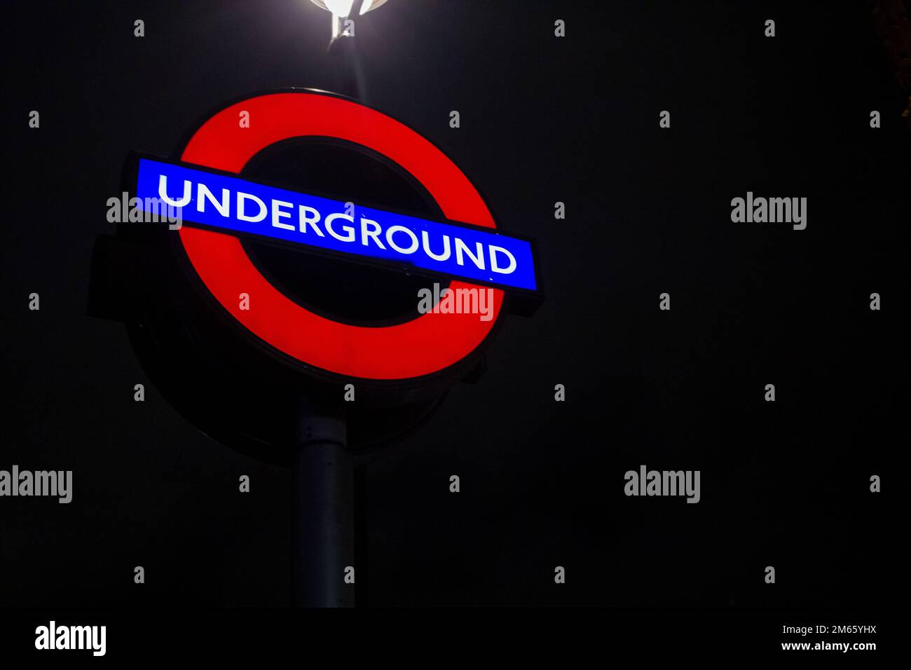L'iconica insegna della metropolitana di Londra di notte Foto Stock