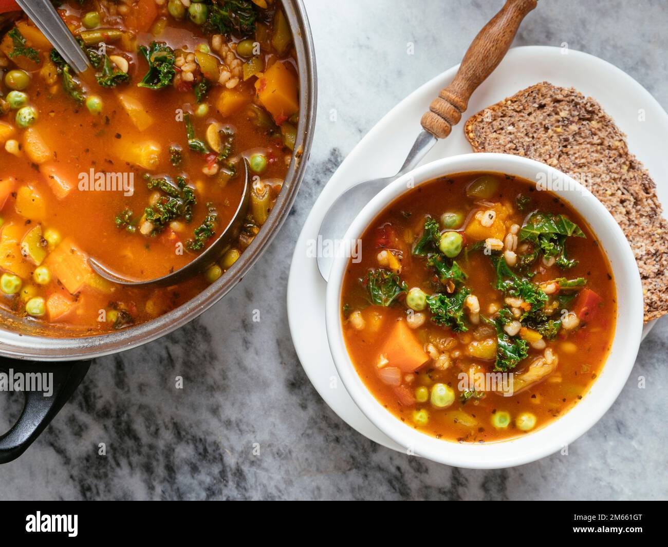 Minestrone italiano fatto in casa con zucca invernale, carote, cavolo, fagioli verdi, piselli, pomodori e orzo. Foto Stock