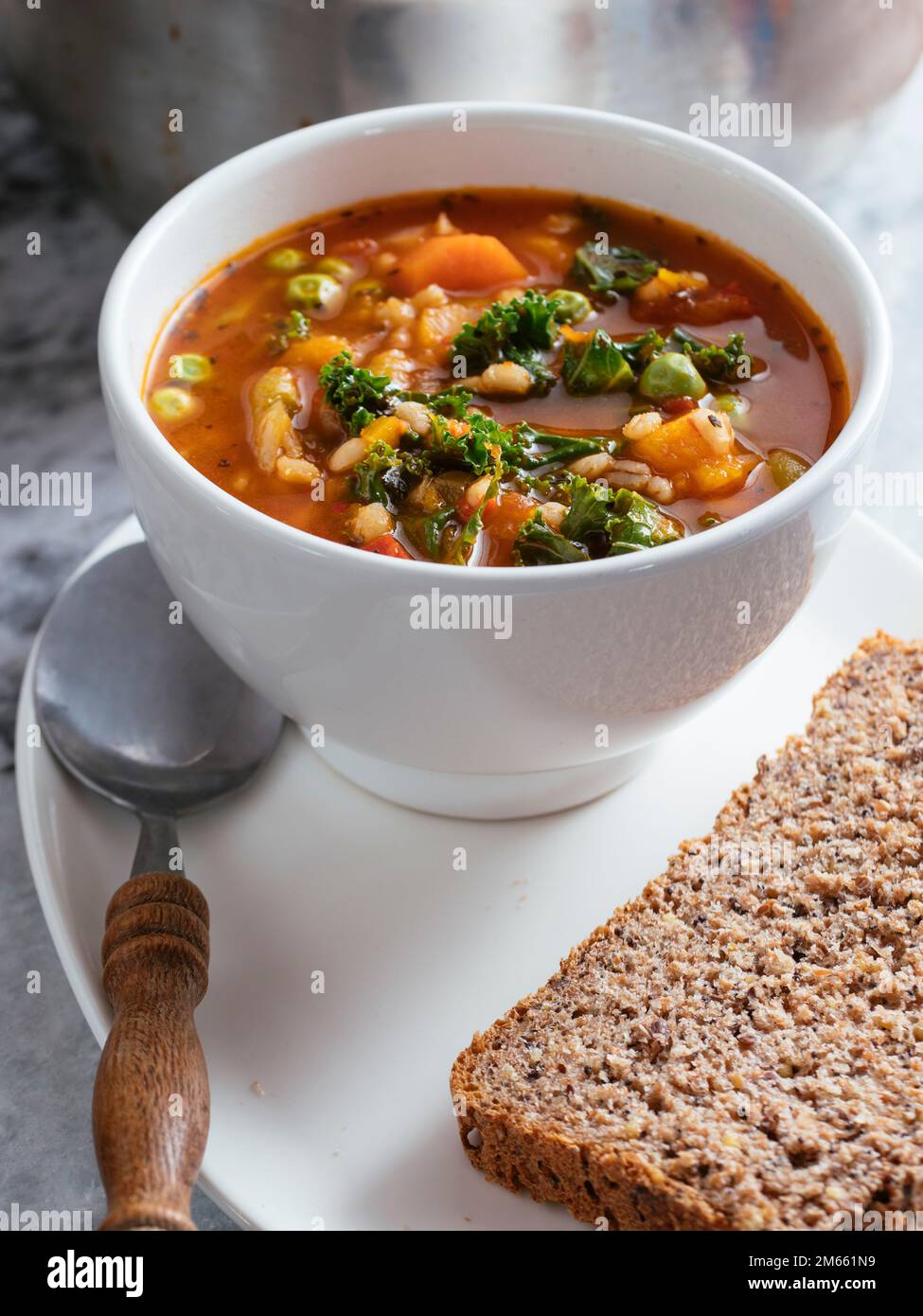 Minestrone italiano fatto in casa con zucca invernale, carote, cavolo, fagioli verdi, piselli, pomodori e orzo. Foto Stock