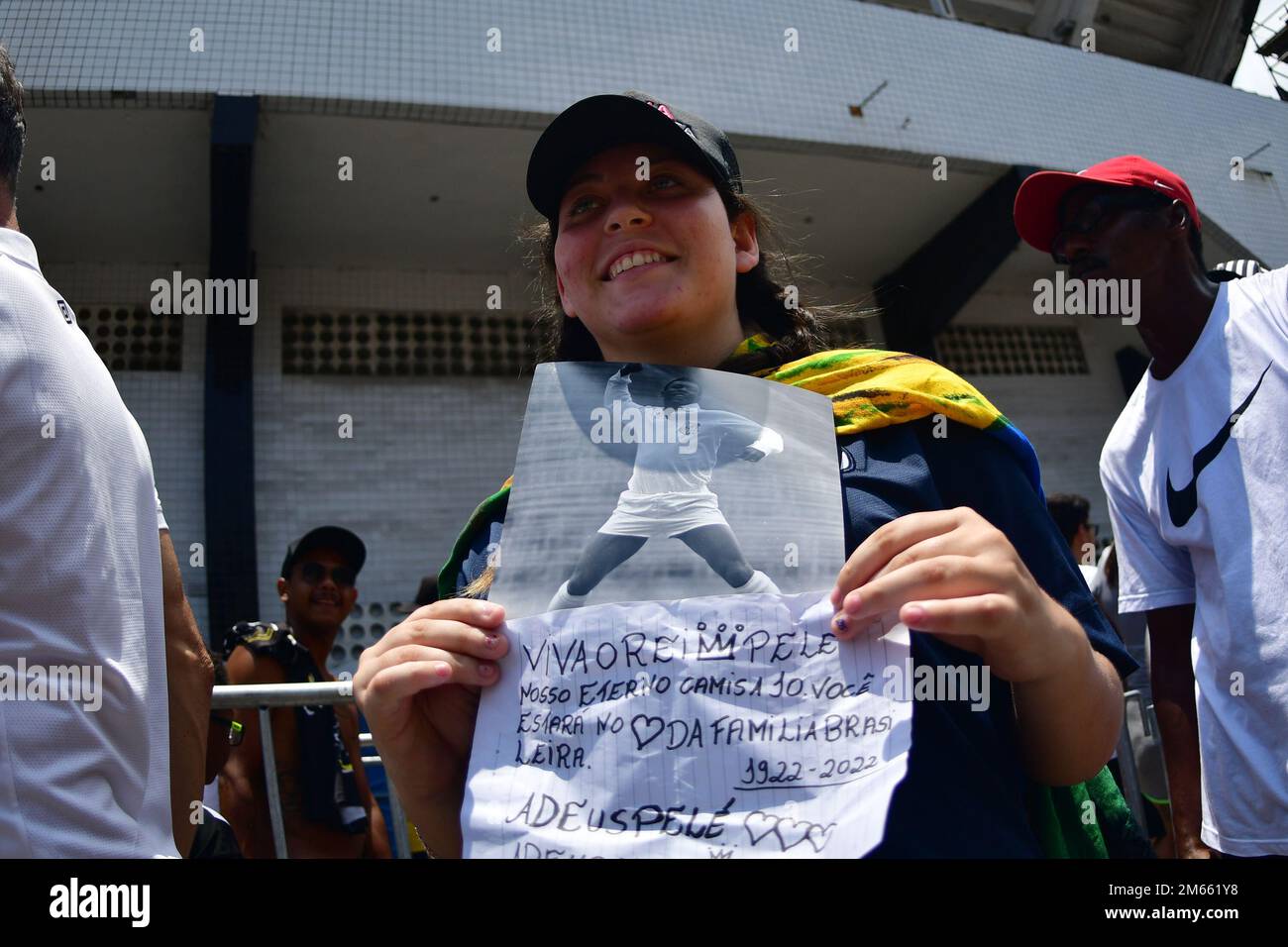 Santos, Brasile. 02nd Jan, 2023. SANTOS, SP - GENNAIO 2: Un giovane fan tiene un banner con le foto di Pele durante i suoi funerali allo Stadio Vila Belmiro il 2 Gennaio 2023 a Santos, Brasile. La leggenda del calcio brasiliano è passata via dal cancro. (Foto di Leandro Bernardes/PxImages) Credit: PX Images/Alamy Live News Foto Stock