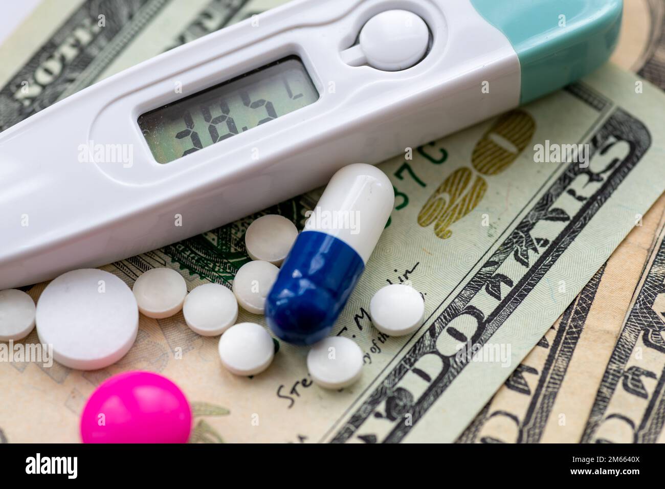 Primo piano della medicina e un termometro in cima alle fatture del dollaro. Costo di cura di salute, concetto di pharma grande. Foto Stock