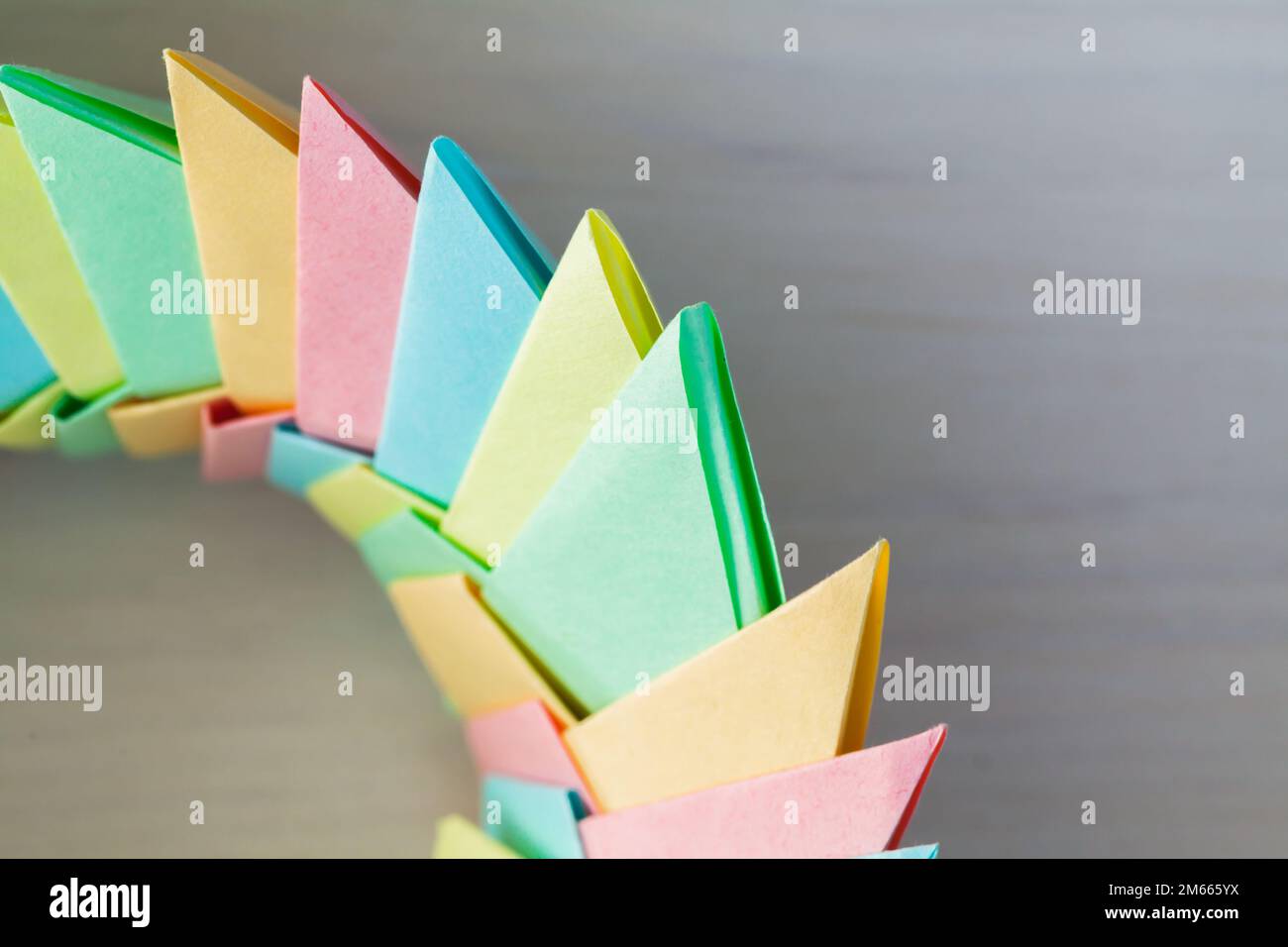 Colorato anello origami su sfondo bianco, struttura parametrica astratta in fogli di carta, foto ravvicinata con soft focus selettivo Foto Stock