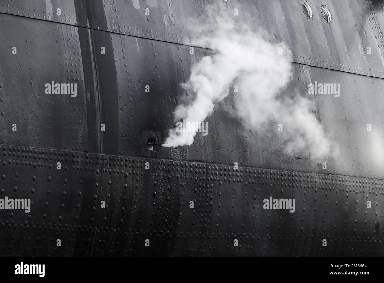 Il vapore bianco esce dallo scafo nero della nave, foto astratta industriale Foto Stock