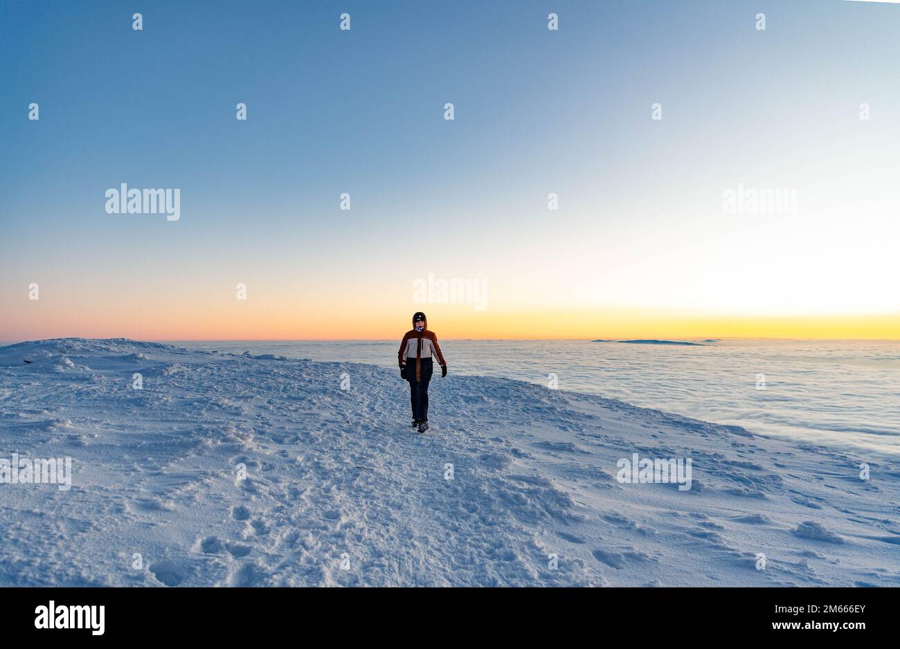 Ragazzo adolescente in una giacca invernale calda su un sentiero invernale di montagna Foto Stock