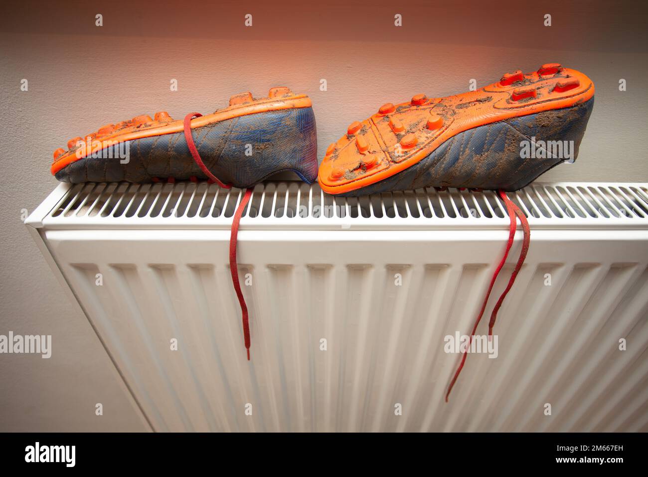 Scarpe da calcio sul radiatore Foto Stock
