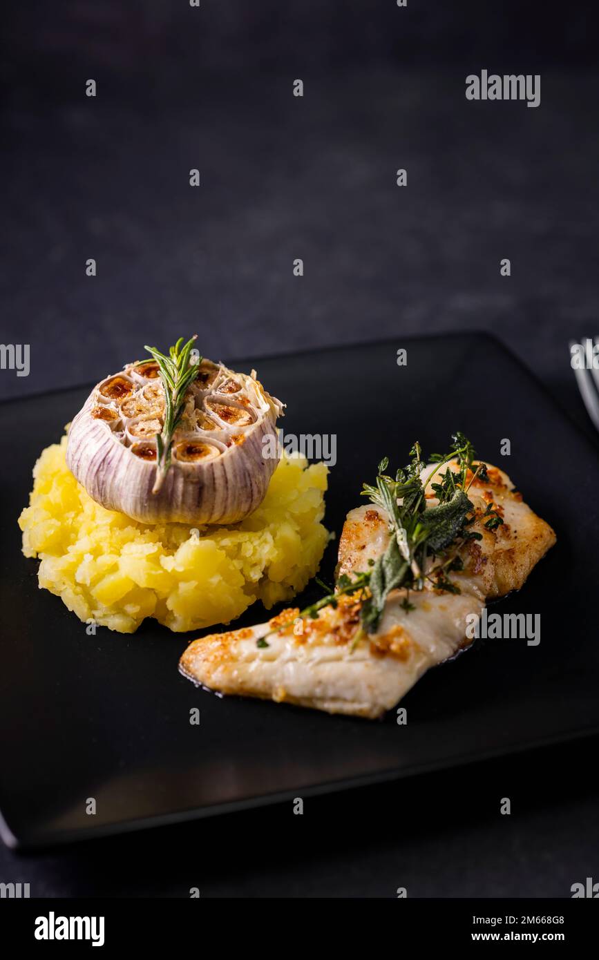 filetto di merluzzo con couscous e aglio arrostito Foto Stock