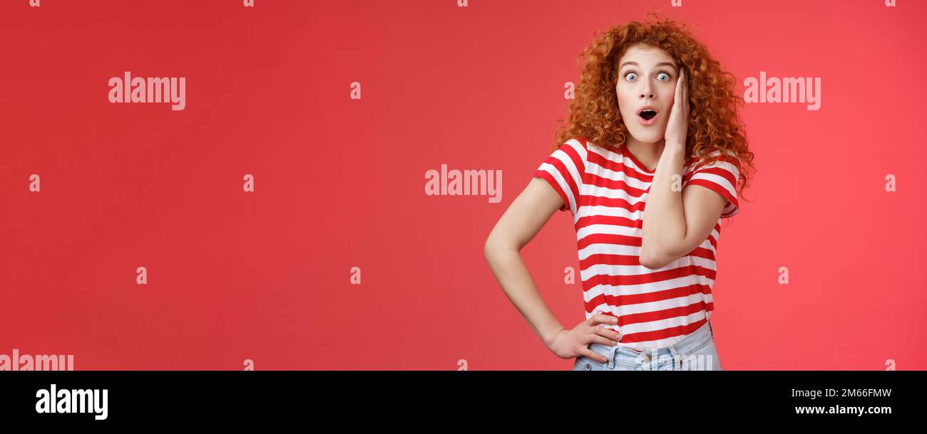 Shocked Amused emotive redhead zenzero ragazza ricci capelli chiazzare occhi fotocamera affascinato bocca aperta gasping divertito react Foto Stock