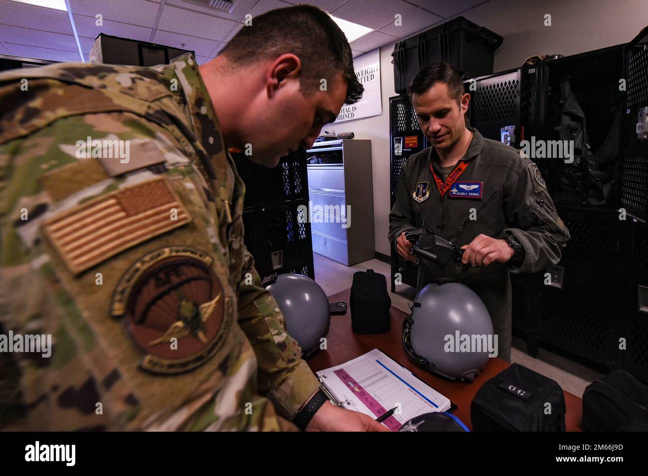 STATI UNITI Air National Guard Tech. Jaden Krump (a sinistra), tecnico di attrezzature di volo dell'equipaggio, 114th Fighter Wing, rilascia un sistema di gueing montato su casco congiunto agli Stati Uniti Anthony Demma, pilota, 114th Fighter Wing, durante il corso Weapons and Tactics Instructor (WTI) 2-22 alla Marine Corps Air Station Yuma, Ariz., 7 aprile 2022. WTI è un evento di formazione di sette settimane ospitato da Marine Aviation Weapons and Tactics Squadron One, che fornisce formazione tattica avanzata standardizzata e la certificazione delle qualifiche di istruttore di unità per supportare la formazione e la preparazione dell'aviazione marina e assistere Foto Stock