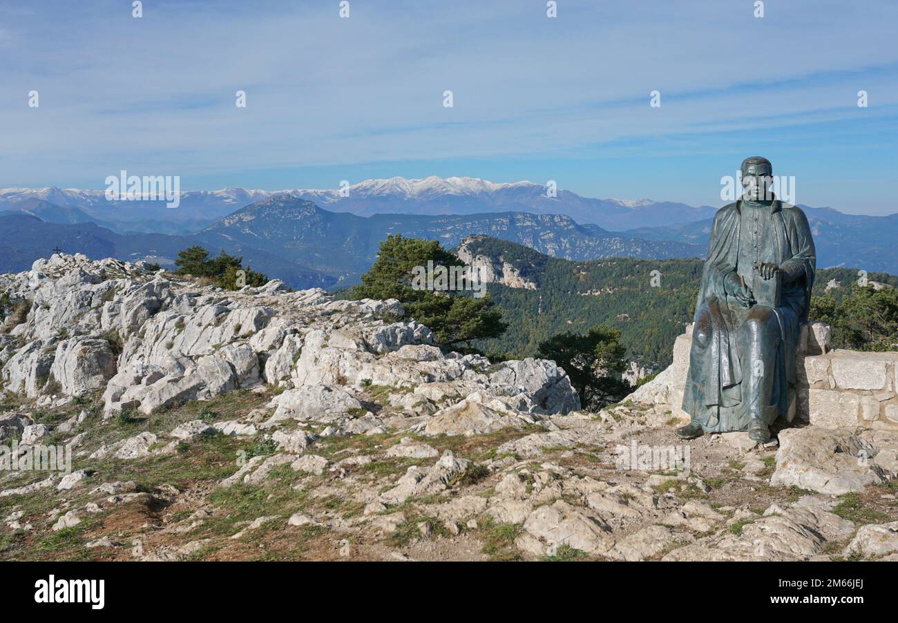 Paesaggio montano dalla cima del Mare de Deu del Mont con la scultura di Jacint Verdaguer in primo piano, alta Garrotxa, Catalogna, Spagna Foto Stock