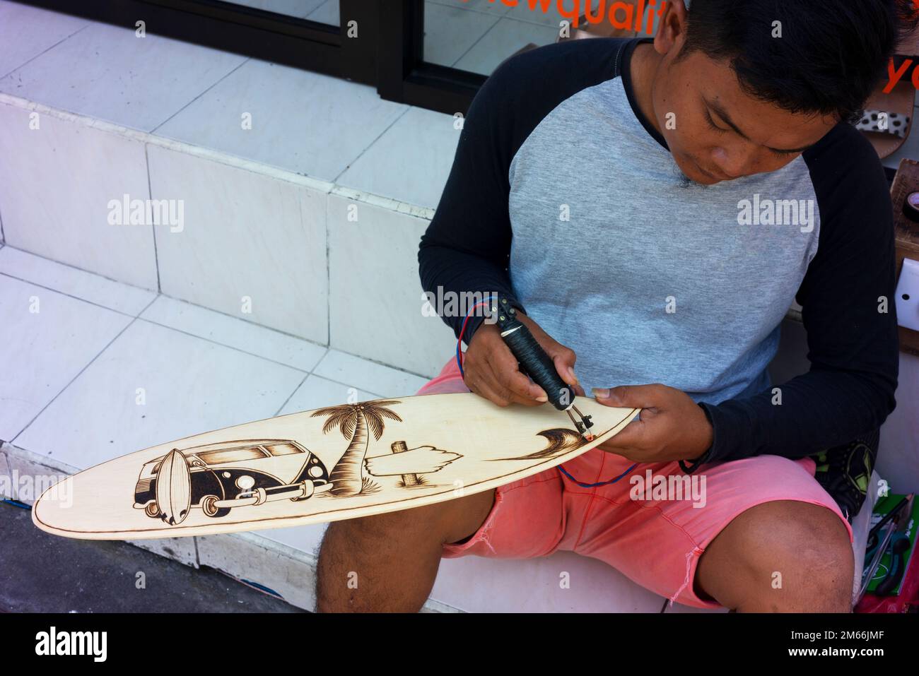 Artista che crea un pezzo d'arte per il mercato turistico di Kuta. Foto Stock