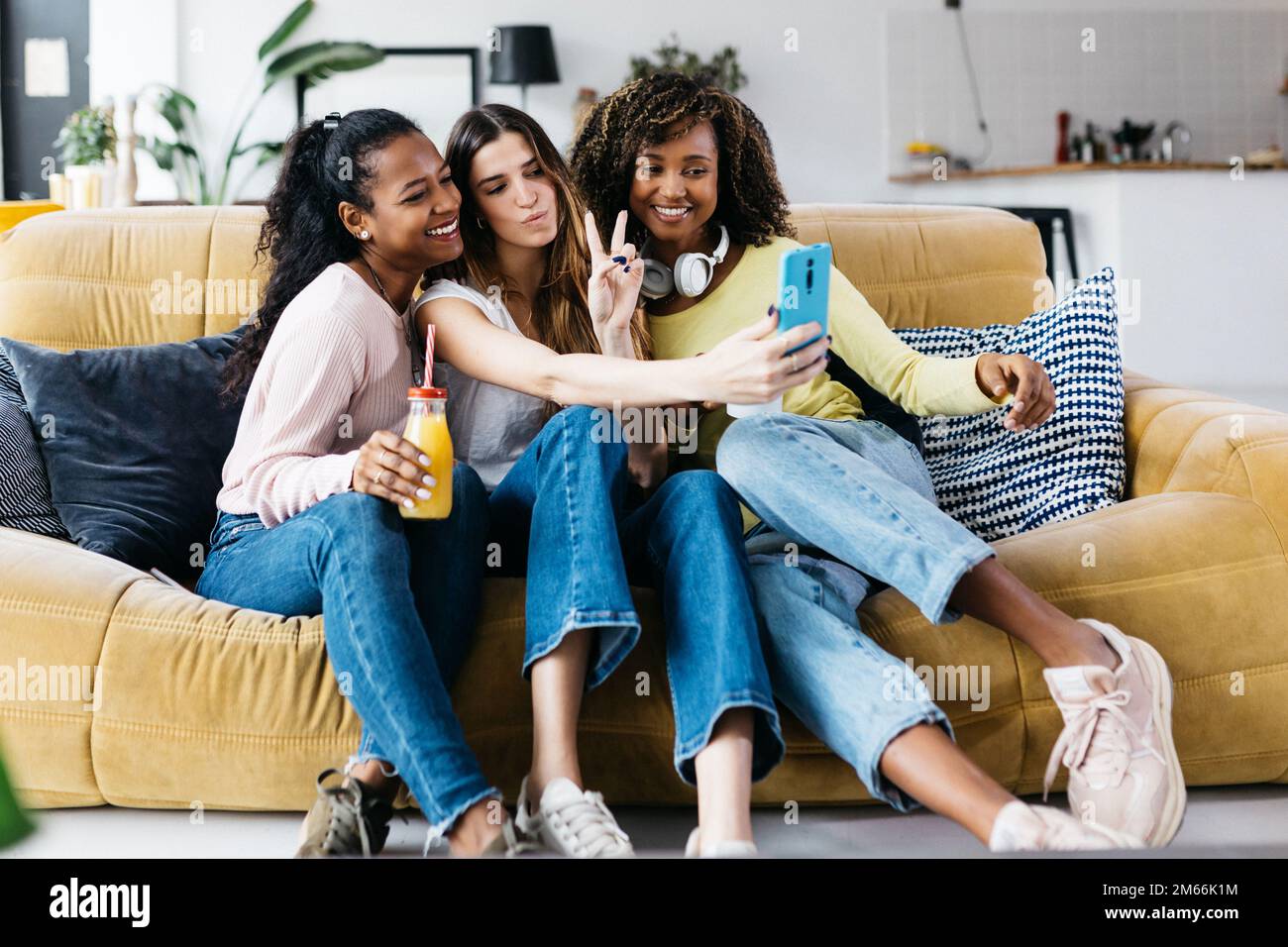 Allegre e diverse amiche che si divertono a prendere il selfie con il telefono Foto Stock