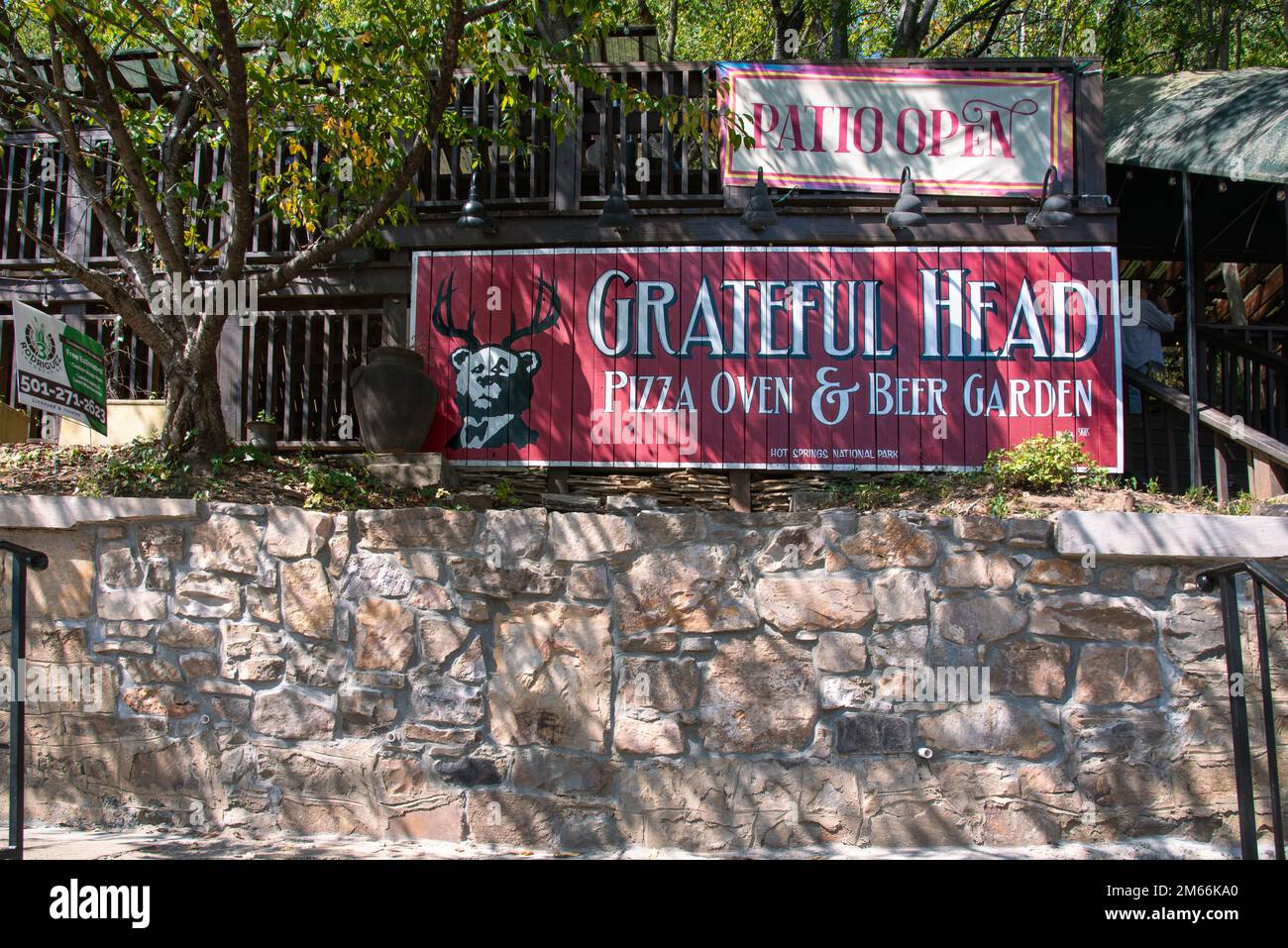 Grande cartello rosso per il ristorante Grateful Head Pizza Oven e Beer Garden in cima a un muro di pietra nel centro di Hot Springs, Arkansas. Foto Stock