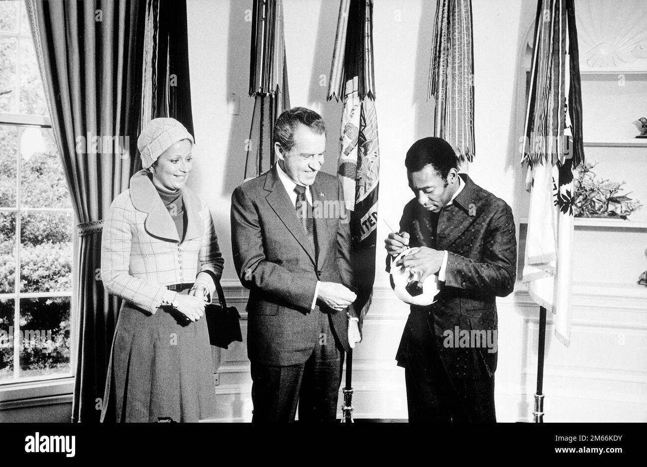 Il presidente Nixon incontra Edson 'Pele' Arantes do Nacimento, ex giocatore di calcio brasiliano e direttore del programma internazionale di calcio sponsorizzato da PepsiCo. 'Pele' autografa una palla di calcio per il presidente Nixon, 1973 Foto Stock