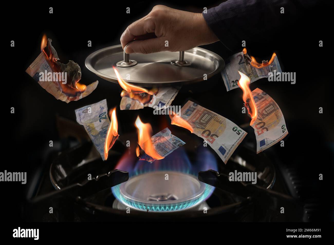 Gas price cap concept (tedesco Gaspreisdeckel), stufa con fiamme, bruciare banconote in euro volando verso l'alto, mano che tiene un coperchio pentola sopra di esso per limitare il p Foto Stock
