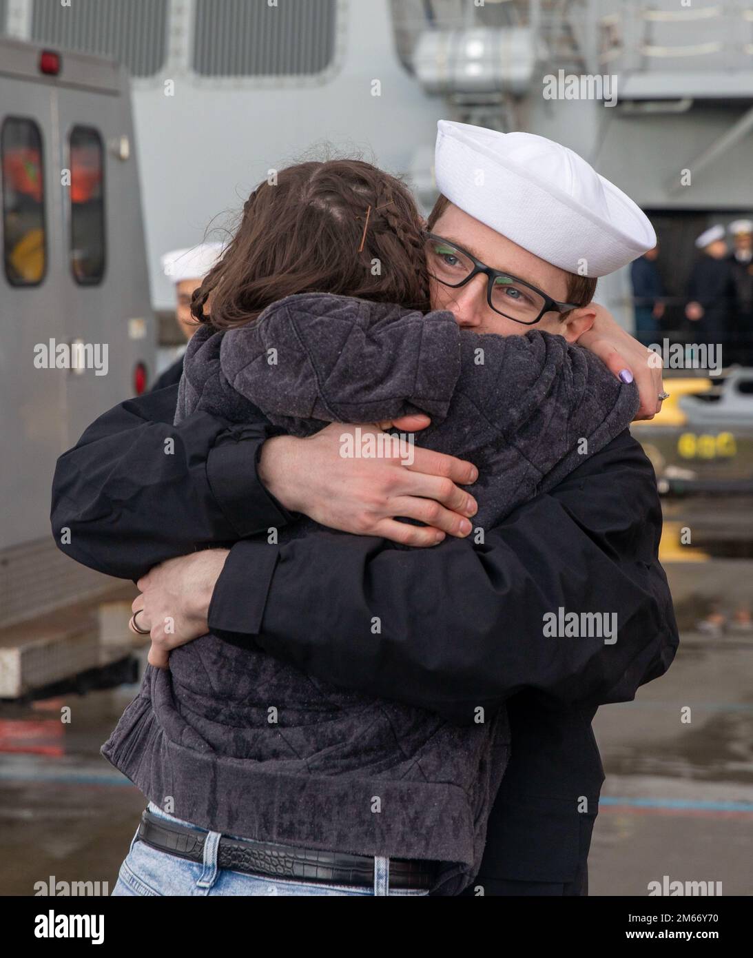 Un Sailor si riunisce con la sua famiglia dopo che il cacciatorpediniere missilistico guidato della classe Arleigh Burke USS McCampbell (DDG 85) è arrivato al suo nuovo homeport della Stazione Navale di Everett, Washington il 8 aprile 2022. Prima della delocalizzazione, la nave ha subito un lungo periodo di modernizzazione del deposito a Portland, Oregon, che ha avuto una durata superiore a 18 mesi. La modernizzazione includeva miglioramenti allo scafo, ai sistemi meccanici, alla tecnologia elettrica, alle comunicazioni wireless e agli aggiornamenti delle armi. Questa manutenzione ordinaria garantisce che la nave possa continuare ad essere in grado di svolgere le proprie funzioni per tutta la durata prevista. Foto Stock
