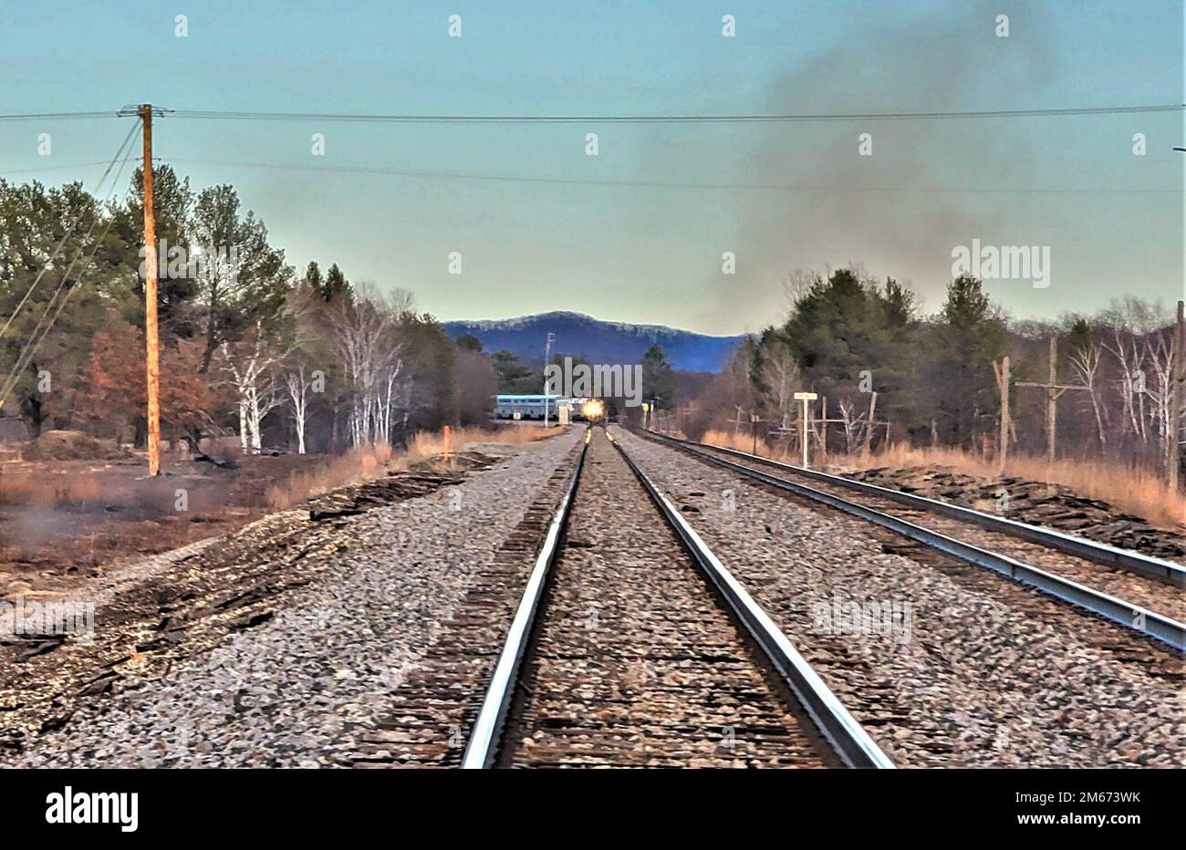 Un treno commerciale si sfreccia lungo i binari del 9 aprile 2022, a Fort McCoy, Wisconsin. Viene istituita una rete ferroviaria completa nella zona di South Post and cantonment di Fort McCoy, mentre i treni commerciali, talvolta lunghi chilometri, passano regolarmente attraverso l'installazione tra Tomah e Sparta, Wisconsin. La rotaia è stata un costante fissaggio all'installazione da quando è stata aperta più di 100 anni fa. Foto Stock