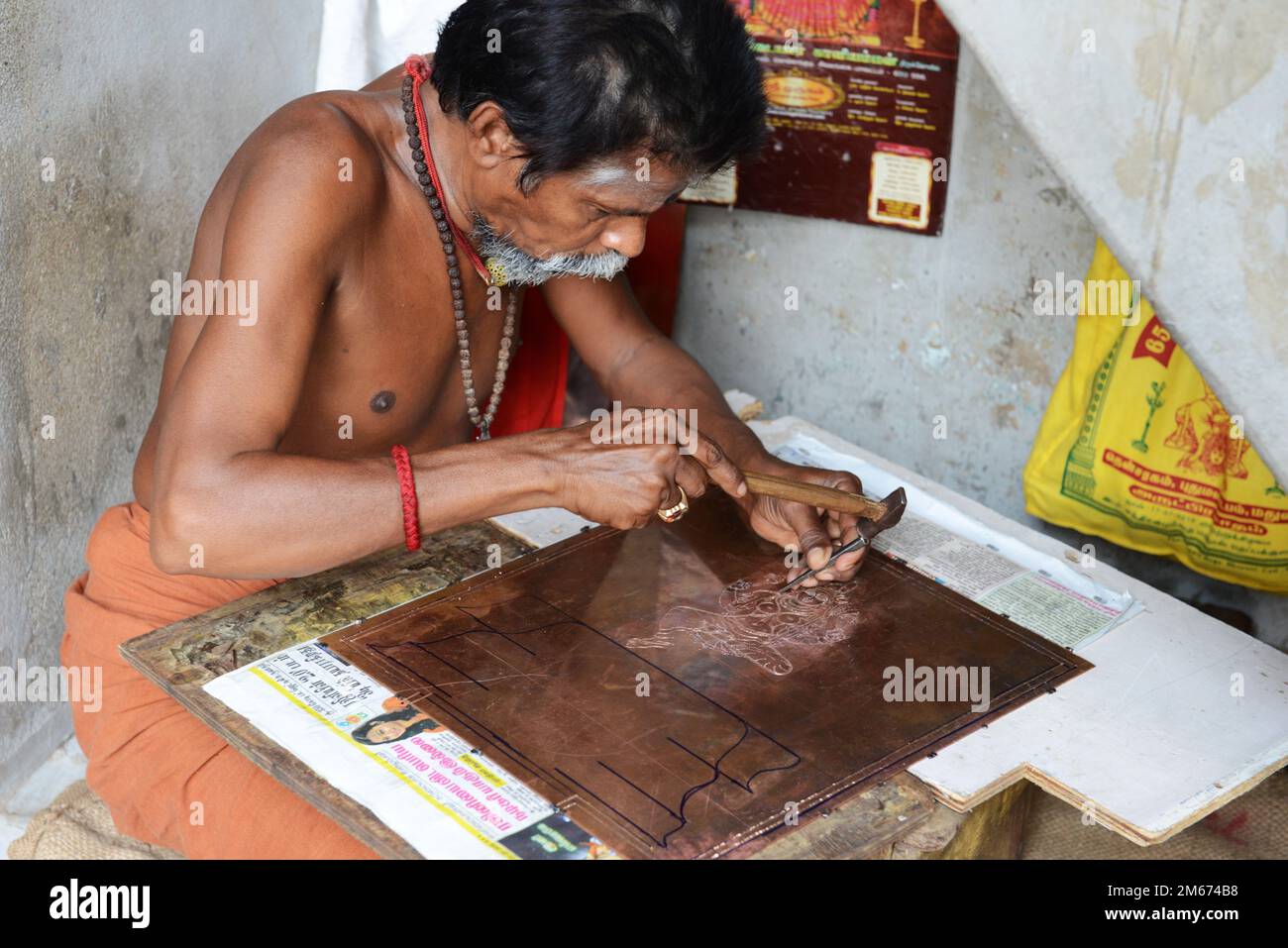 Un artigiano che lavora nel suo laboratorio nei terreni del Tempio di Meenakshi Amman a Madurai, Tamil Nadu, India. Foto Stock