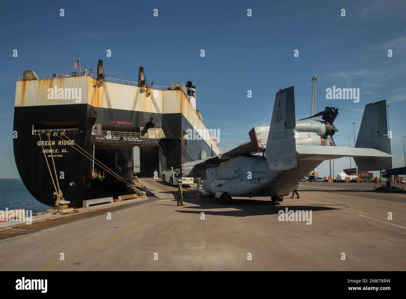 STATI UNITI Marines con Marine Medium Tiltrotor Squadron (VMM) 268 rinforzato, Air Combat Element, Marine Rotational Force-Darwin (MRF-D) 22, spingere un MV-22 Osprey fuori da una nave da carico a Darwin Port, NT, Australia, 11 aprile 2022. L'apparecchiatura VMM 268 è arrivata a Darwin come parte dell'iterazione MRF-D 22. Foto Stock