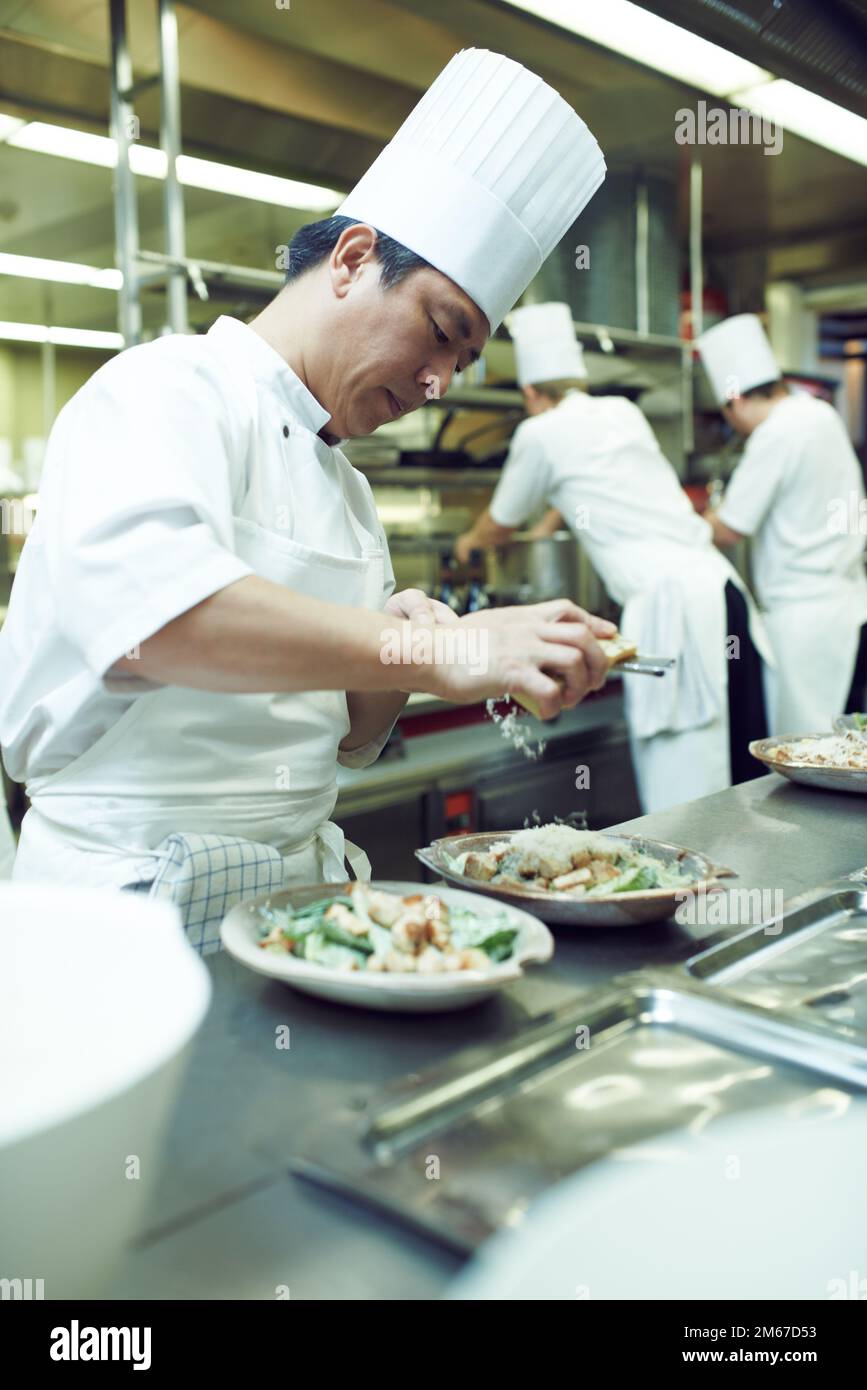Preparazione per l'assistenza. chef che preparano un servizio di pasto in una cucina professionale. Foto Stock