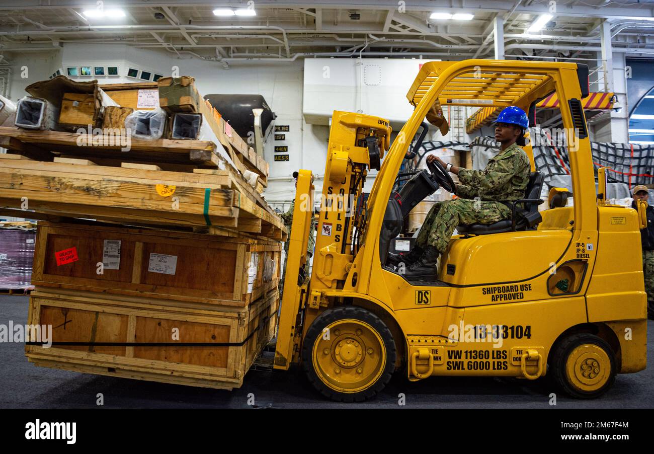 220412-N-EE352-1074 SAN DIEGO (12 aprile 2022) Logistics Specialist 2nd Class Shanice Jones, nativo di Fort Lauderdale, Florida, gestisce un carrello elevatore durante un'operazione di fornitura nella baia hangar della portaerei di classe Nimitz USS Carl Vinson (CVN 70), aprile 12. Vinson è attualmente pierside nel suo homeport di San Diego. Foto Stock