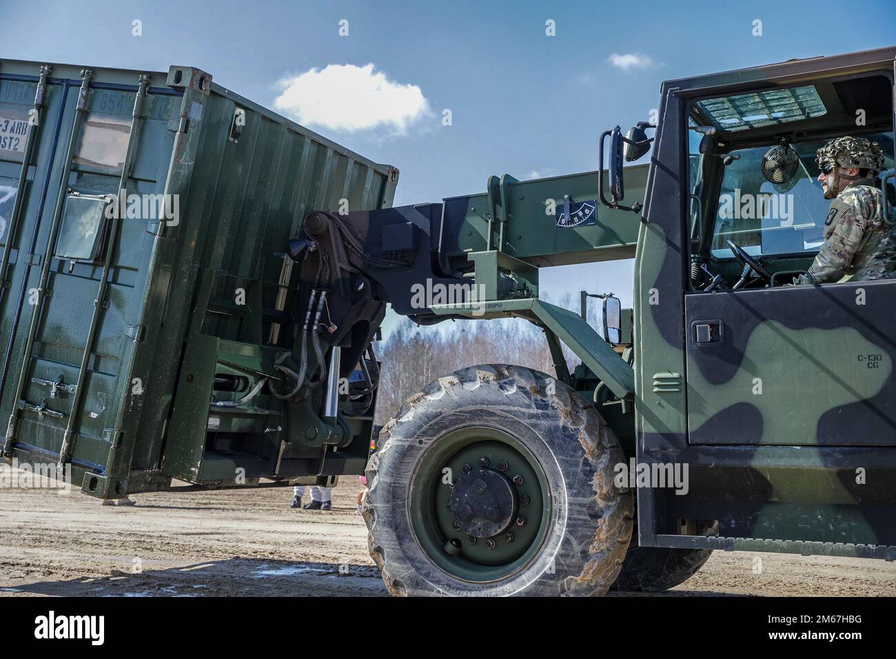STATI UNITI Personale dell'esercito. Patrick Rush, sergente di munizioni, assegnato a Echo Company, 1-3rd Battaglione di attacco, 12th Brigata di Aviazione di combattimento, muove i contenitori di trasporto in sostegno del lavaggio agricolo del battaglione a Lielvarde Air base, Lettonia il 12 aprile 2022. Un lavaggio agricolo è fondamentale per proteggere e mantenere gli investimenti degli agricoltori dagli organismi che causano malattie del pollame. Patrick è originario di Tampa Bay, Florida, dove ha lavorato come un lavoratore di costruzione che pavimentava le strade. È entrato a far parte degli Stati Uniti Esercito nel 2014, a causa di una promessa fatta a suo nonno che avrebbe servito il suo paese. Upo Foto Stock