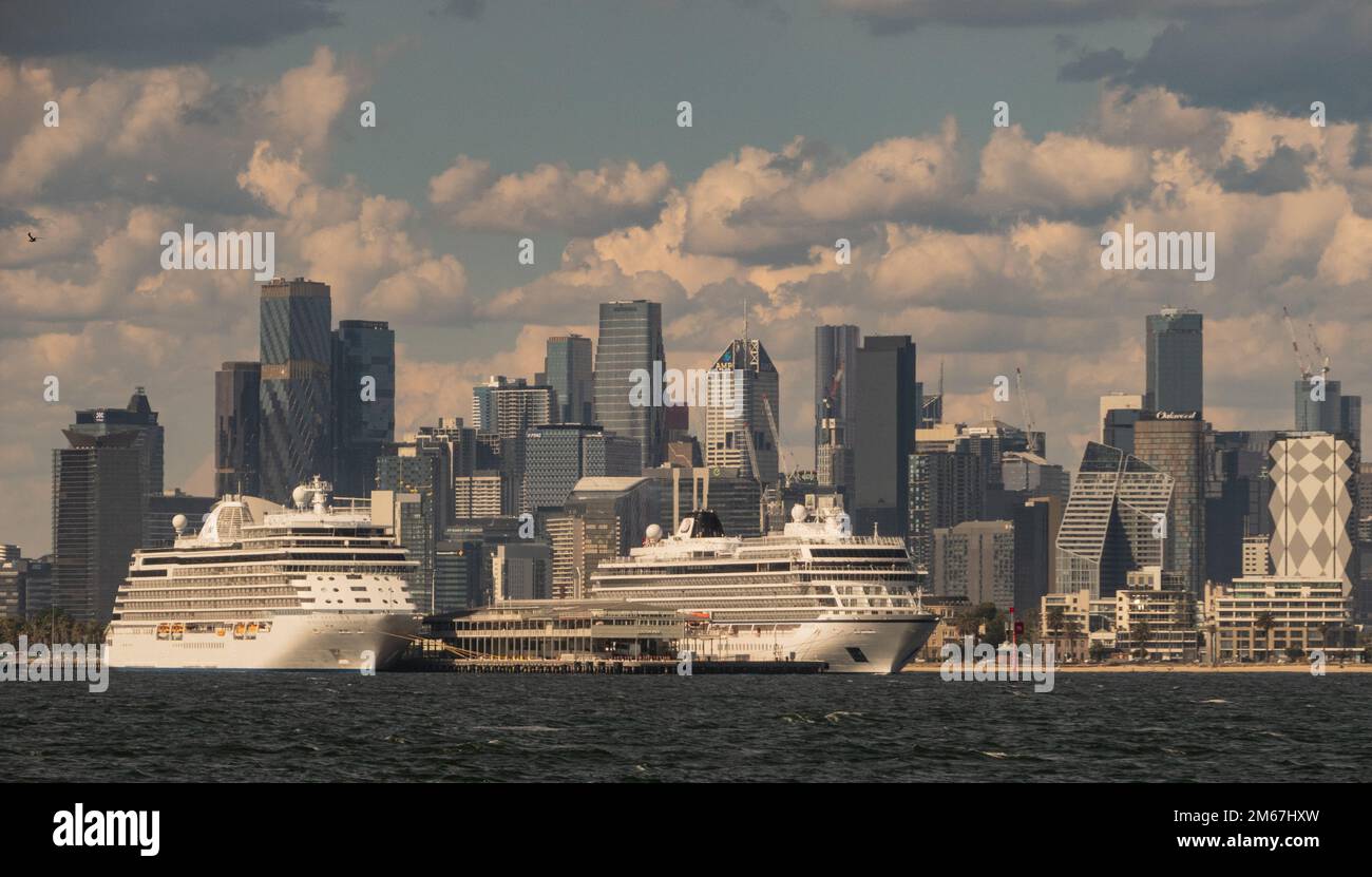 Le navi da crociera sono ormeggiate al Molo della Stazione a Port Melbourne con lo skyline della citta' di Melbourne sullo sfondo. Foto Stock