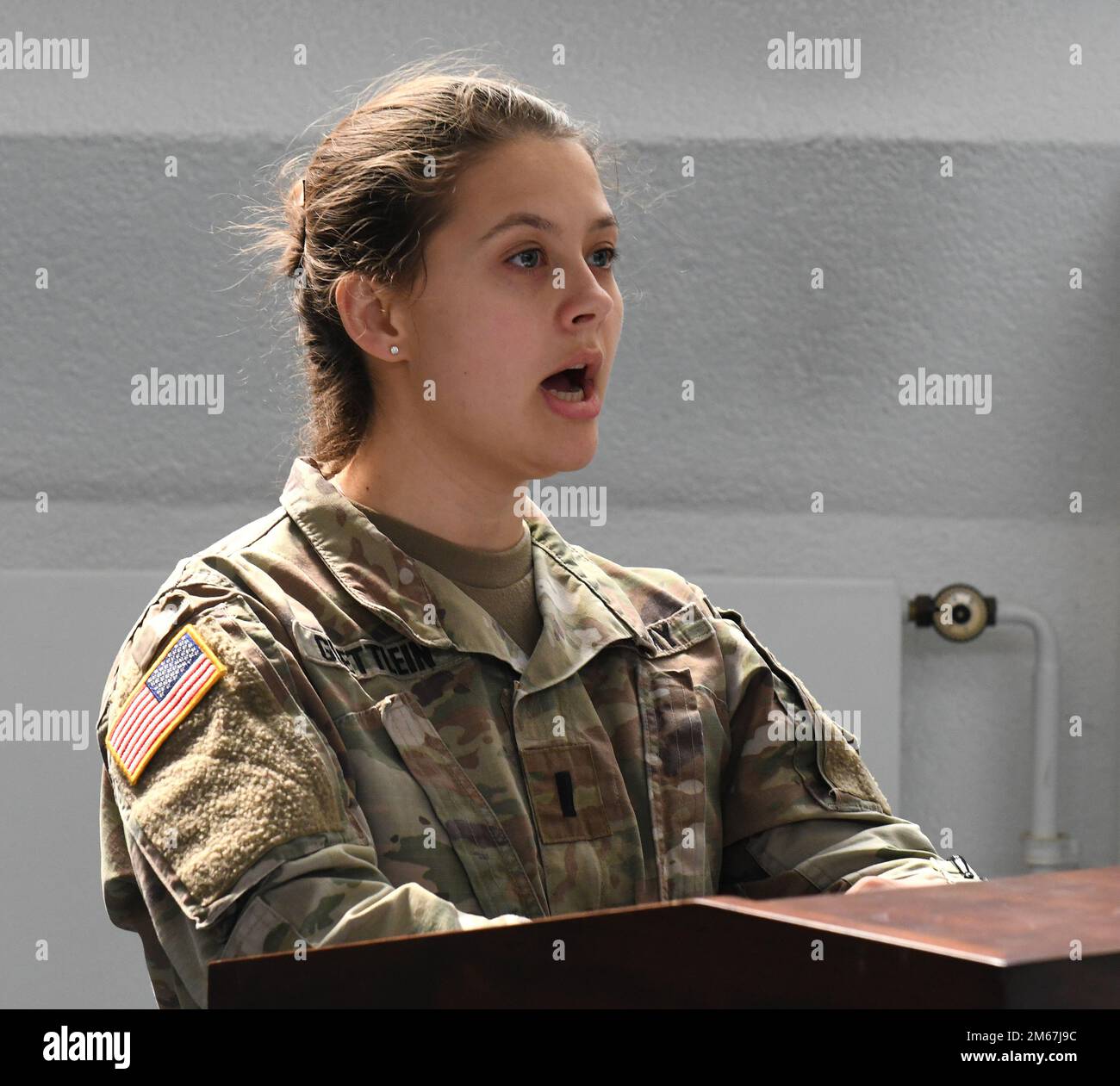 STATI UNITI L'esercito 1st Lt. Katherine Guettlein con l'esercito 10th Air and Missile Defense Command canta l'inno nazionale tedesco e americano durante il St. La cerimonia di premiazione di Barbara, 12 aprile 2022, presso la cappella di Sembach, in Germania. I premi rappresentavano l'adesione all'Ordine di San Barbara, il santo patrono dell'artiglieria. Foto Stock