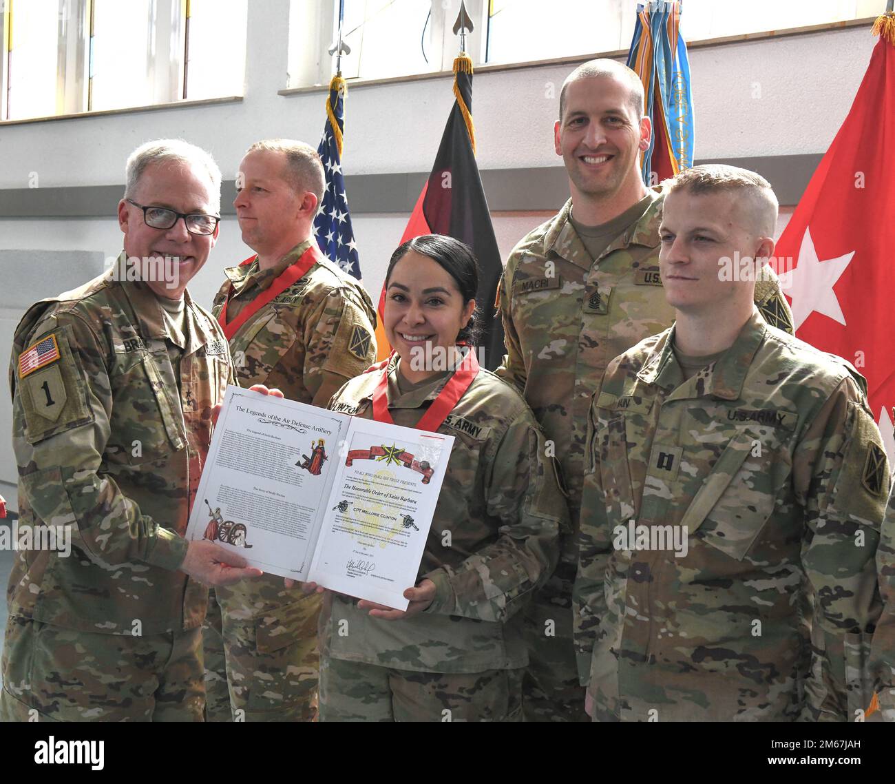 STATI UNITI Gregory Brady e il comando Sgt. Giancarlo Macri, 10th° comando militare per la Difesa aerea e missilistica presente CPT. Mellorie Clinton (centro) con un certificato e medaglione durante la cerimonia di premiazione dell’Onorabile Ordine di Santa Barbara il 12 aprile 2022 alla Cappella di Sembach, in Germania. I premi rappresentavano l'adesione all'Ordine di San Barbara, il santo patrono dell'artiglieria. Foto Stock