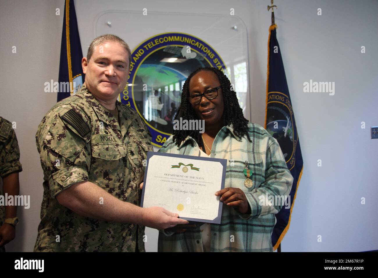Il CDR Nichols presenta la Sig.ra Roberlyn Burke con una Medaglia al conseguimento del Servizio civile. Foto Stock