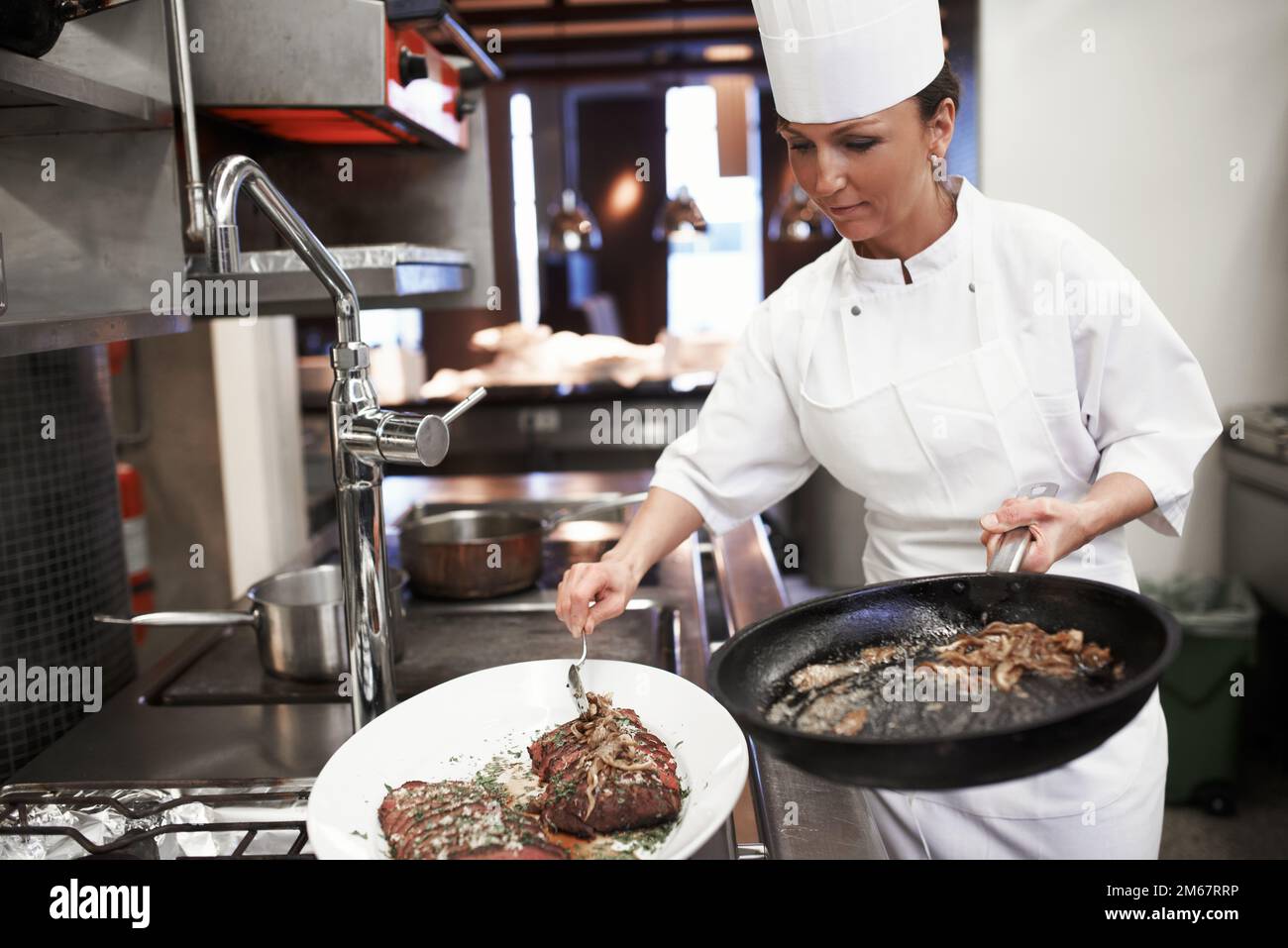 Cibo per l'anima. chef che preparano un servizio di pasto in una cucina professionale. Foto Stock