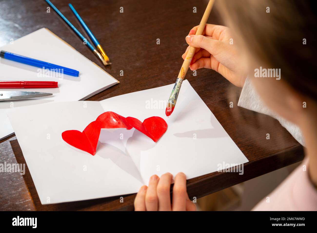 Pittura a mano vi amo con vernice rossa su carta bianca. Primo piano sulla creazione del biglietto di auguri di San Valentino. Foto Stock