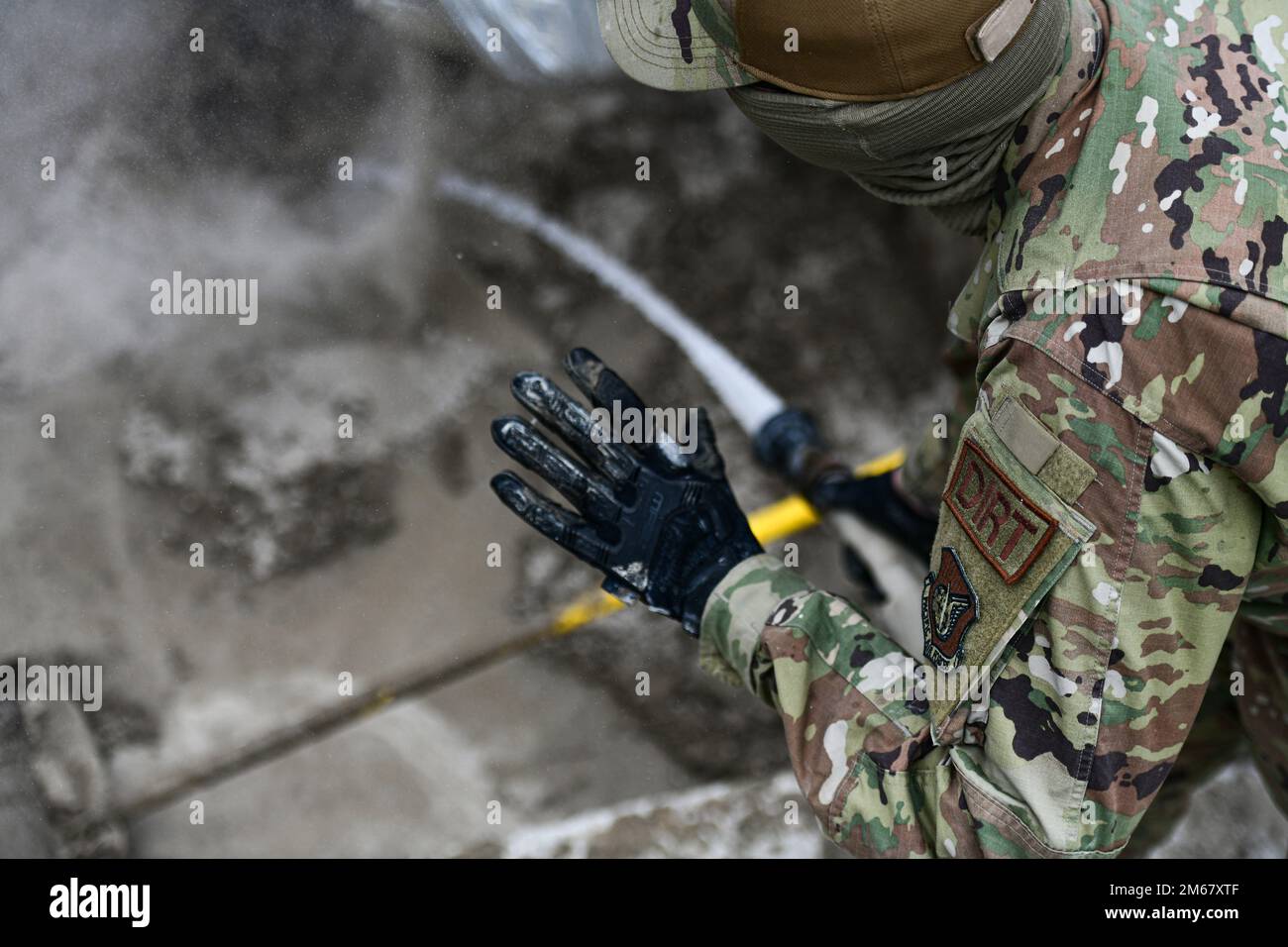 Airman Basic Josiah Ward, 8th ingegnere civile pavimenti Squadron e l'apprendista attrezzature pesanti, spruzza un tubo di acqua per creare cemento durante la formazione di Rapid Airfield Damage Repair alla base aerea di Kunsan, Repubblica di Corea, 14 aprile 2022. Gli Airmen del CES 8th hanno eseguito RADR, un esercizio di allenamento per riparare rapidamente una pista, garantendo che la flotta di F-16 Fighting Falcons di Kunsan decolli in modo sicuro dalla linea di volo. Foto Stock