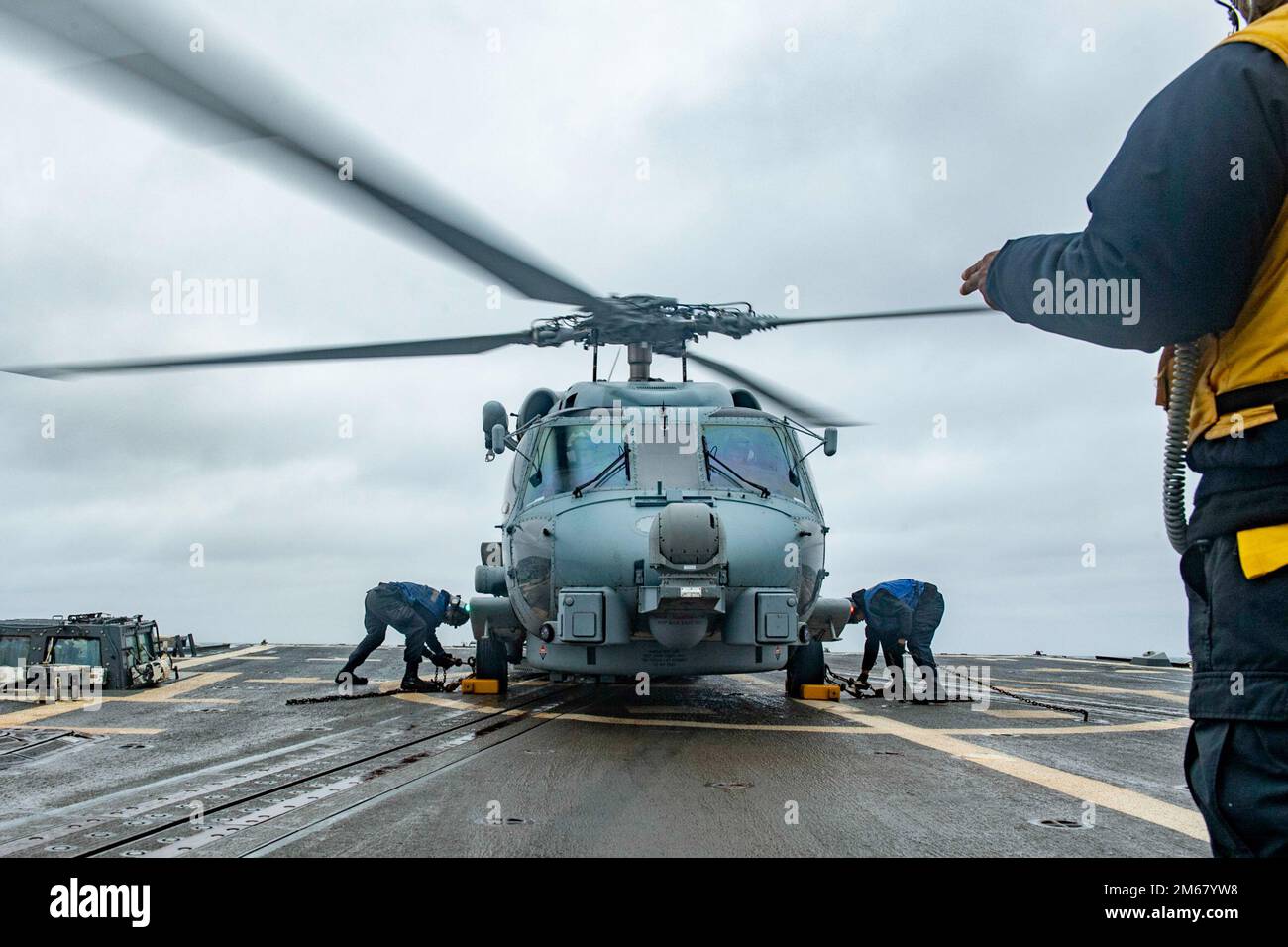 A DEL GIAPPONE (13 aprile 2022) i marinai scocchiolano e catene un elicottero MH-60R Sea Hawk assegnato ai “Raptors” dell’elicottero Maritime Strike Squadron (HSM) 71 sul ponte di volo del cacciatorpediniere missilistico guidato di classe Arleigh Burke USS Spruance (DDG 111). Abraham Lincoln Strike Group è in fase di implementazione pianificata nell'area delle operazioni della flotta 7th degli Stati Uniti per migliorare l'interoperabilità attraverso alleanze e partnership e al tempo stesso fungere da forza di risposta pronta a sostegno di una regione indomPacifico libera e aperta. Foto Stock