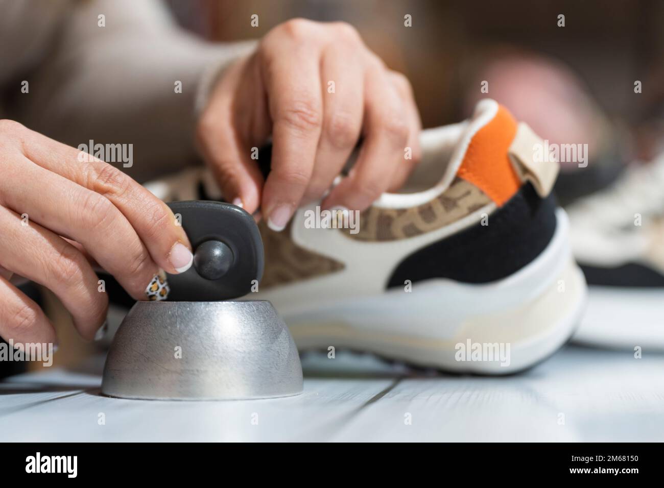 Addetto al negozio di abbigliamento che rimuove l'allarme da un capo di abbigliamento Foto Stock