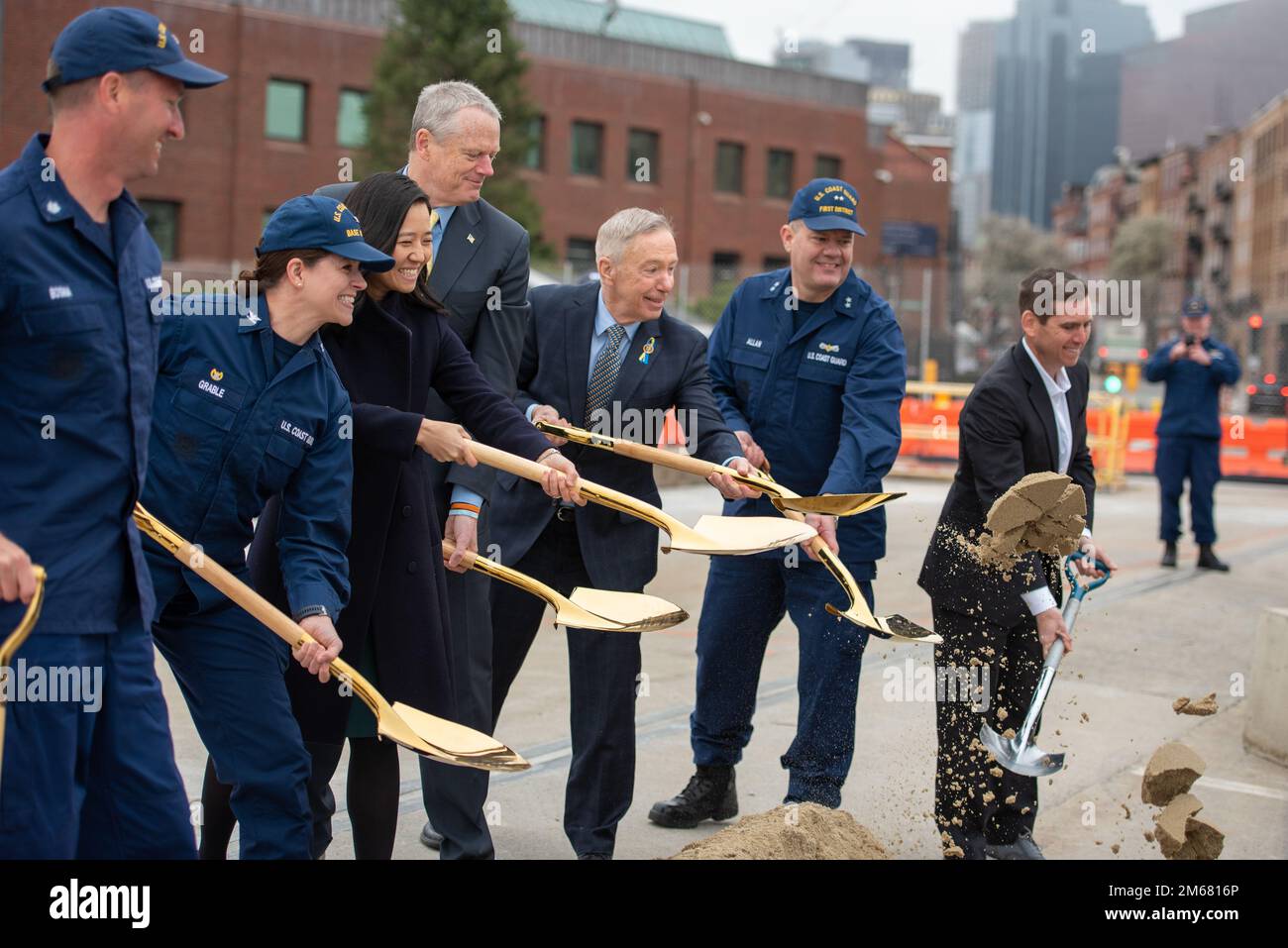 Il Governatore del Massachusetts Charlie Baker, il Rappresentante Stephen Lynch e il Sindaco di Boston Michelle Wu si rompono a terra presso la base della Guardia Costiera di Boston, Massachusetts, durante una cerimonia rivoluzionaria il 14 aprile 2022. La cerimonia inaugurale ha segnato l'inizio di un progetto di ristrutturazione del molo in preparazione all'arrivo di diversi taglierini Fast Response che saranno portati a casa presso la base della Guardia Costiera di Boston. Foto Stock