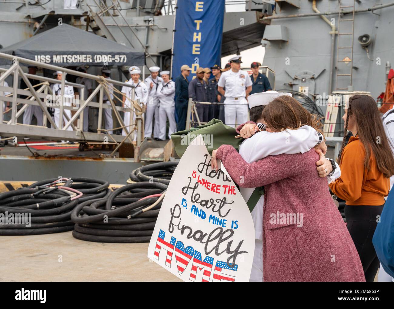 NORFOLK (16 aprile 2022) - Un marinaio assegnato al cacciatorpediniere missilistico guidato della classe Arleigh Burke USS Mitscher (DDG 57), abbraccia sua moglie dopo il ritorno della nave a homeport, stazione navale Norfolk, 16 aprile. Mitscher si è schierato nel teatro europeo delle operazioni e ha partecipato ad una serie di attività marittime a sostegno delle forze navali Europa e alleati della NATO. Foto Stock