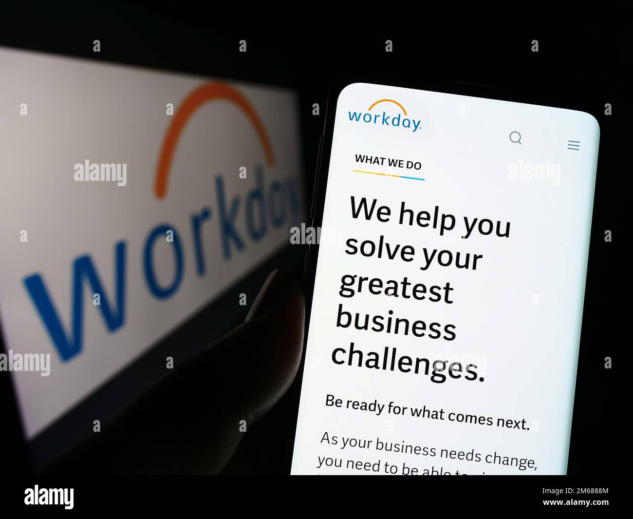 Persona che tiene il cellulare con la pagina web della società di software statunitense Workday Inc. Sullo schermo di fronte al logo. Messa a fuoco al centro del display del telefono. Foto Stock