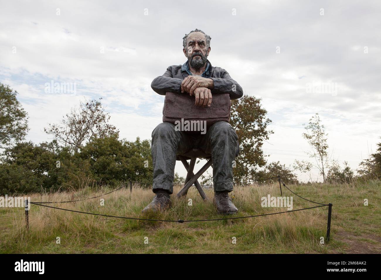 Una scultura di Sean Henry, seduto Figura 2016, presso lo Yorkshire Sculpture Park Foto Stock