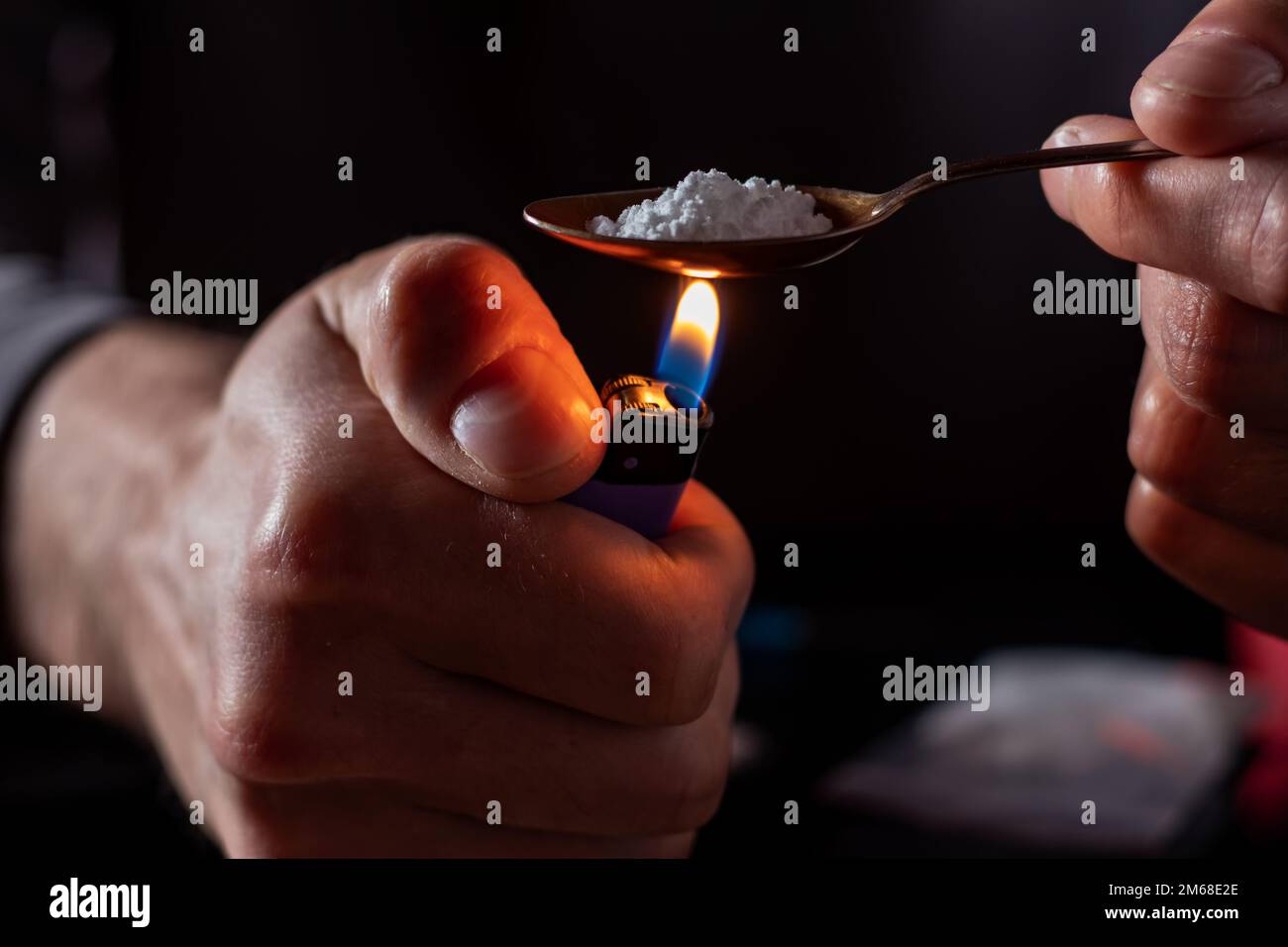 Tossicodipendenti nella stanza buia. Assuma la preparazione di farmaci con un cucchiaio e un accendino. Polvere bianca e una siringa. Concetto di farmaco. Giornata internazionale dell'abuso di droga Foto Stock