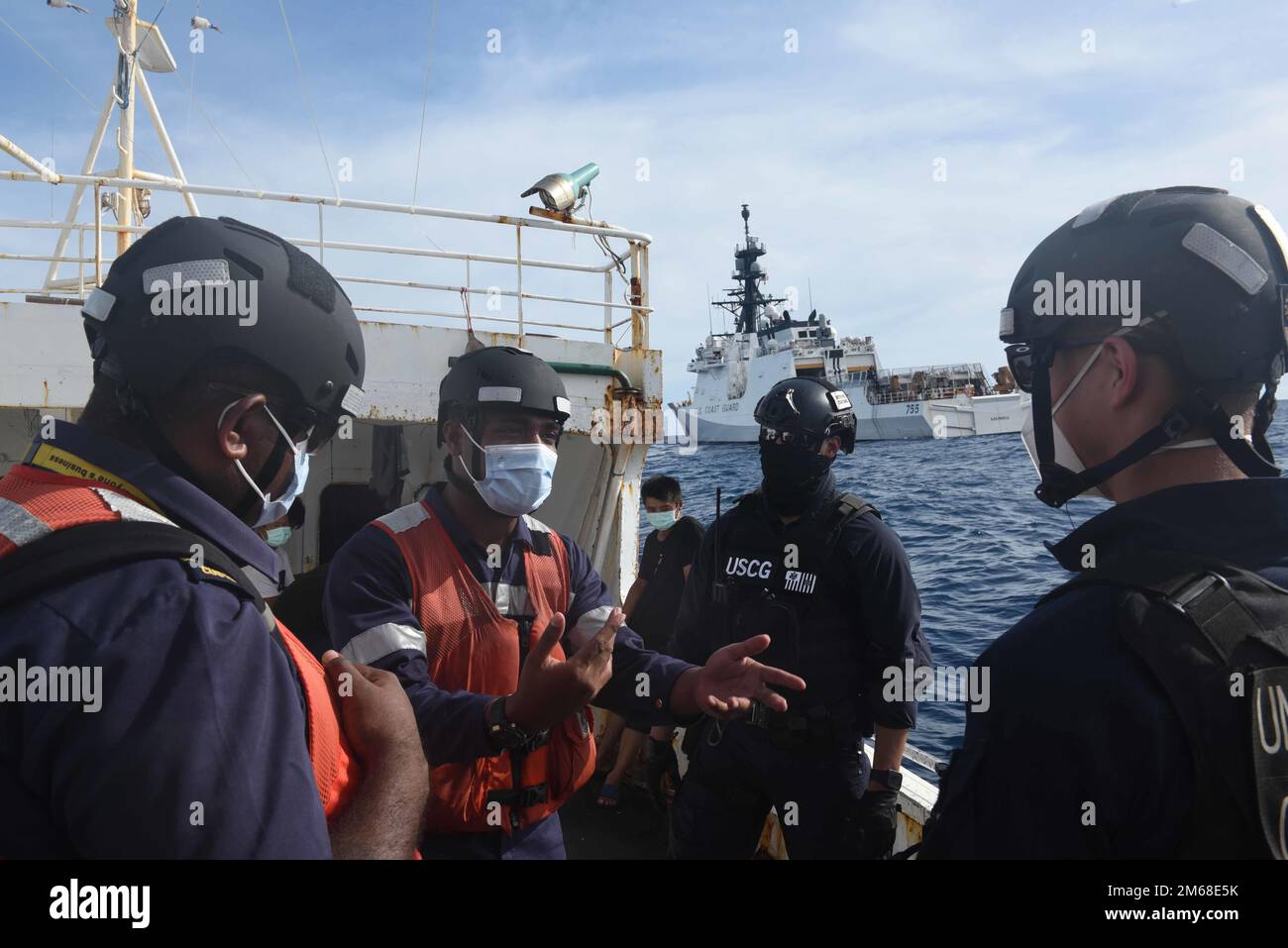 Figi Navy Ens. Peni Koroitubuna discute la procedura con un team composto da funzionari delle forze dell'ordine delle Fiji e degli Stati Uniti Membri dell'equipaggio della Guardia di costa Cutter Munro durante l'imbarco di un peschereccio con bandiera cinese al largo della costa delle Fiji, 18 aprile 2022. Un team di cinque poliziotti delle Fiji ha lavorato con l’equipaggio di Cutter Munro nell’aprile 18-19 come parte dell’operazione Blue Pacific, che mira a contrastare la pesca illegale, non dichiarata e non regolamentata, e a rafforzare le relazioni per rafforzare la sovranità marittima e la sicurezza in tutto l’Indo-Pacifico. Foto Stock