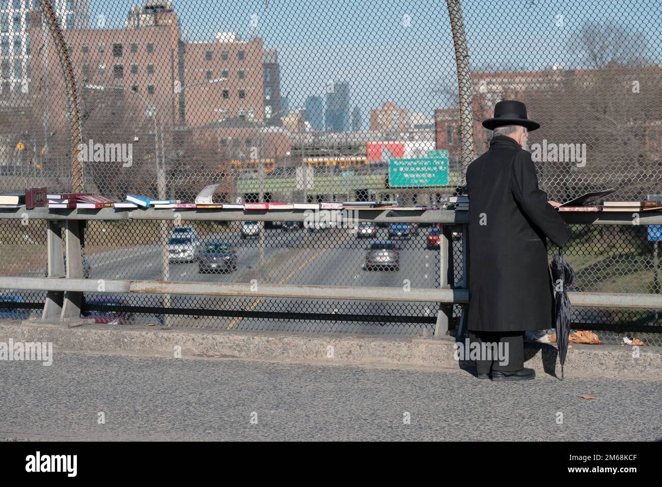 Un vecchio uomo ebraico hassidico fa shopping di libri religiosi in una vendita pop up sul cavalcavia BQE a Brooklyn, New York. Foto Stock