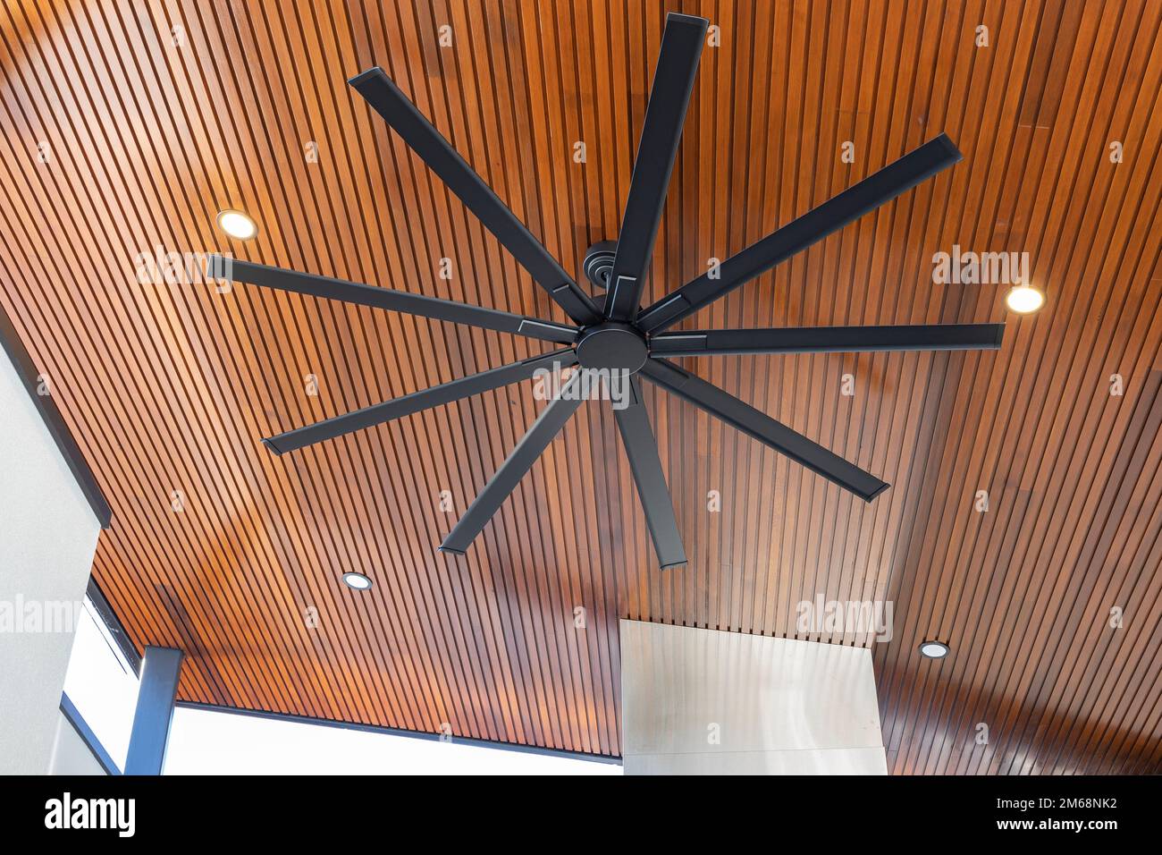 Ventilatore a soffitto all'aperto su un tetto in legno con illuminazione verso il basso Foto Stock