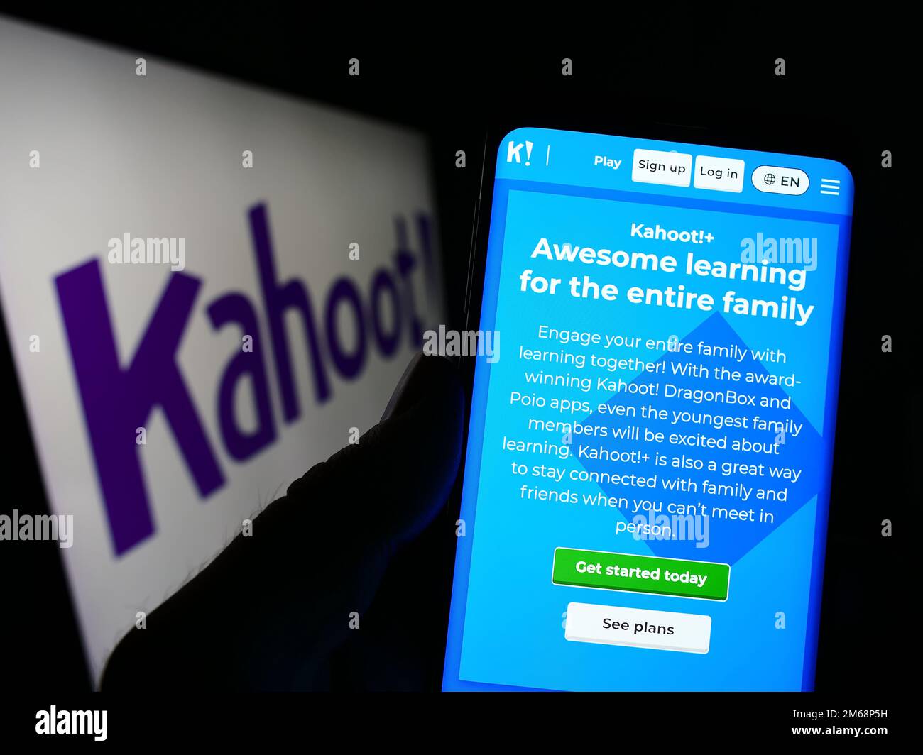 Persona che tiene in mano uno smartphone con la pagina Web della società norvegese di e-learning Kahoot sullo schermo davanti al logo. Messa a fuoco al centro del display del telefono. Foto Stock