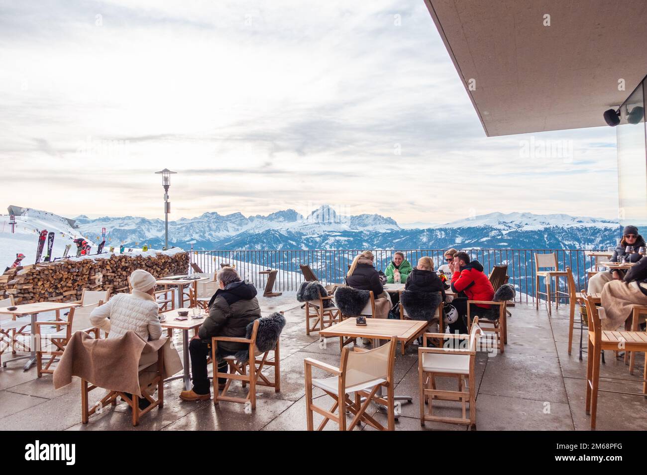 Gruppo di turisti seduti ai tavoli di un caffè in alto nelle Alpi a Plan de Coroes (Plan de Coroes) con le Alpi innevate sullo sfondo. Turisti Foto Stock