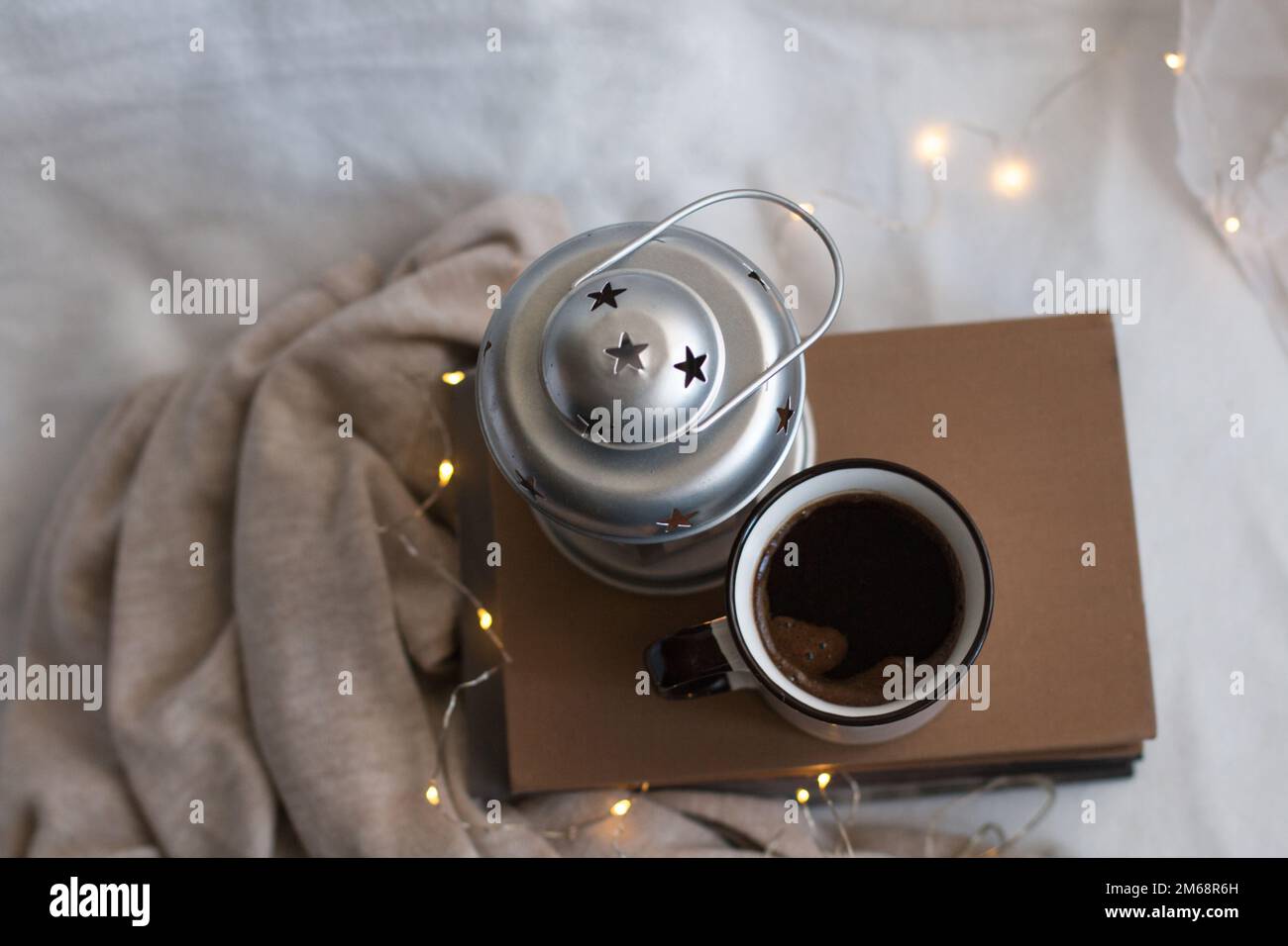Accogliente composizione di caffè, candela e libri per le vacanze. Godere di cose semplici al coperto durante l'inverno. Foto Stock