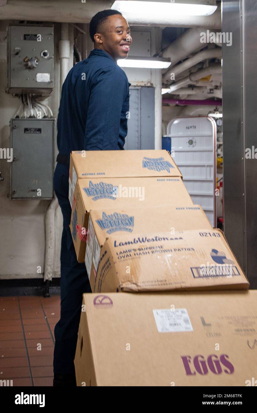 220420-N-EE352-1082 OCEANO PACIFICO (20 aprile 2022) Specialista culinario Seaman Garvin Stubbs, nativo di Freeport, Bahamas, trasporta scatole di cibo a bordo della portaerei di classe Nimitz USS Carl Vinson (CVN 70), aprile 20. Vinson sta attualmente conducendo operazioni marittime di routine nell'Oceano Pacifico. Foto Stock