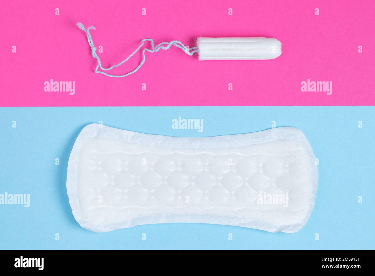 donne tamponi e tamponi - tamponi sanitari si trova accanto a un tampone su uno sfondo isolato su uno sfondo rosa e blu. Igiene femminile e mestruale per Foto Stock