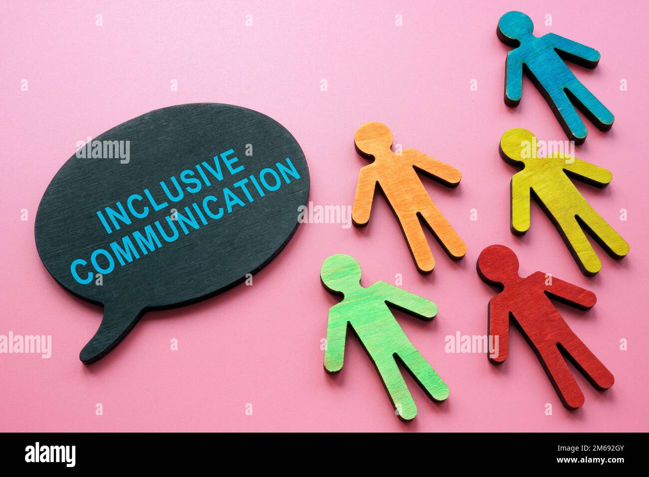Iscrizione di comunicazione inclusiva e piccole figurine colorate. Foto Stock