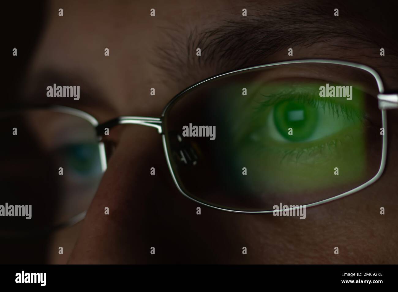 Vista ravvicinata dell'uomo indossa occhiali per ridurre lo sforzo visivo visione offuscata guardando lo schermo del pc con riflessione del computer utilizzando internet, readi Foto Stock